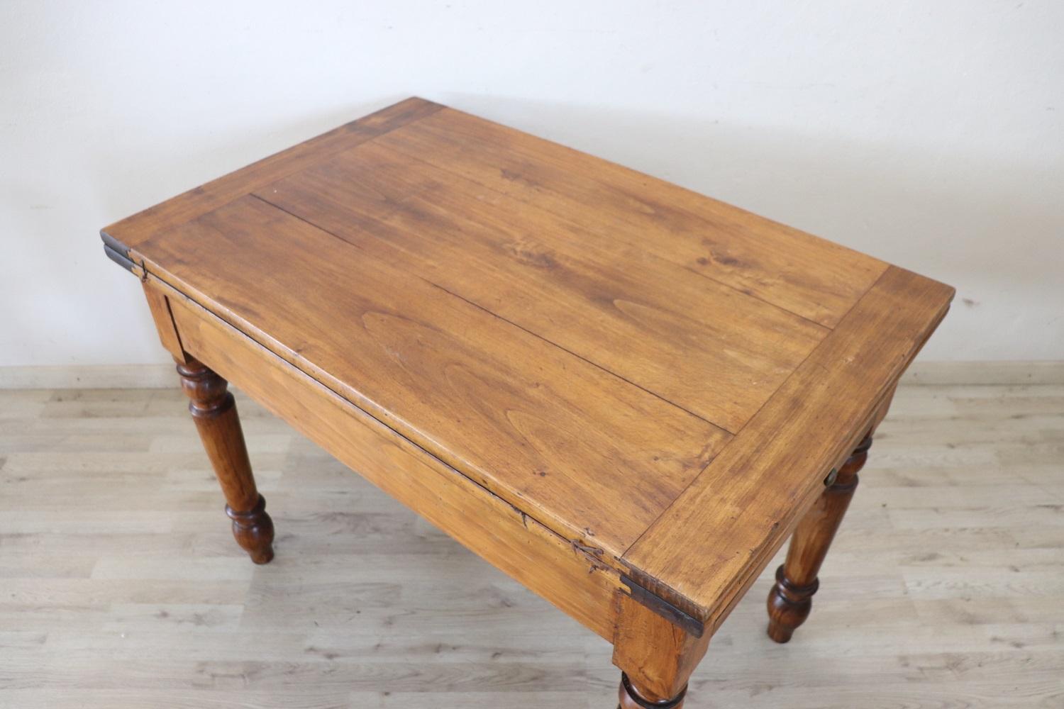 Beautiful very nice Italian solid poplar wood kitchen table, 1850s. The table is very simple and linear, characterized by solid turned legs. Equipped with a drawer and a practical internal compartment. The top of this table opens like a book page