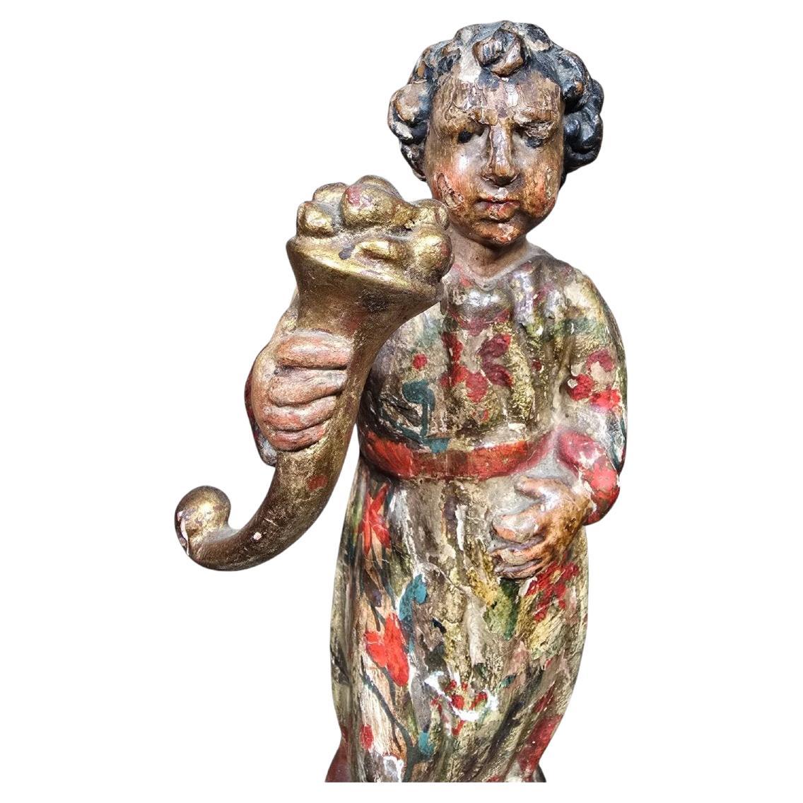 19th Century Italian Sculpture – Boy with a Cornucopia
Dimensions: 33 x 12 x 12 cm
Material: Carved and polychrome wood

A delicate 19th-century Italian sculpture depicting a child holding a cornucopia, a classical symbol of prosperity and