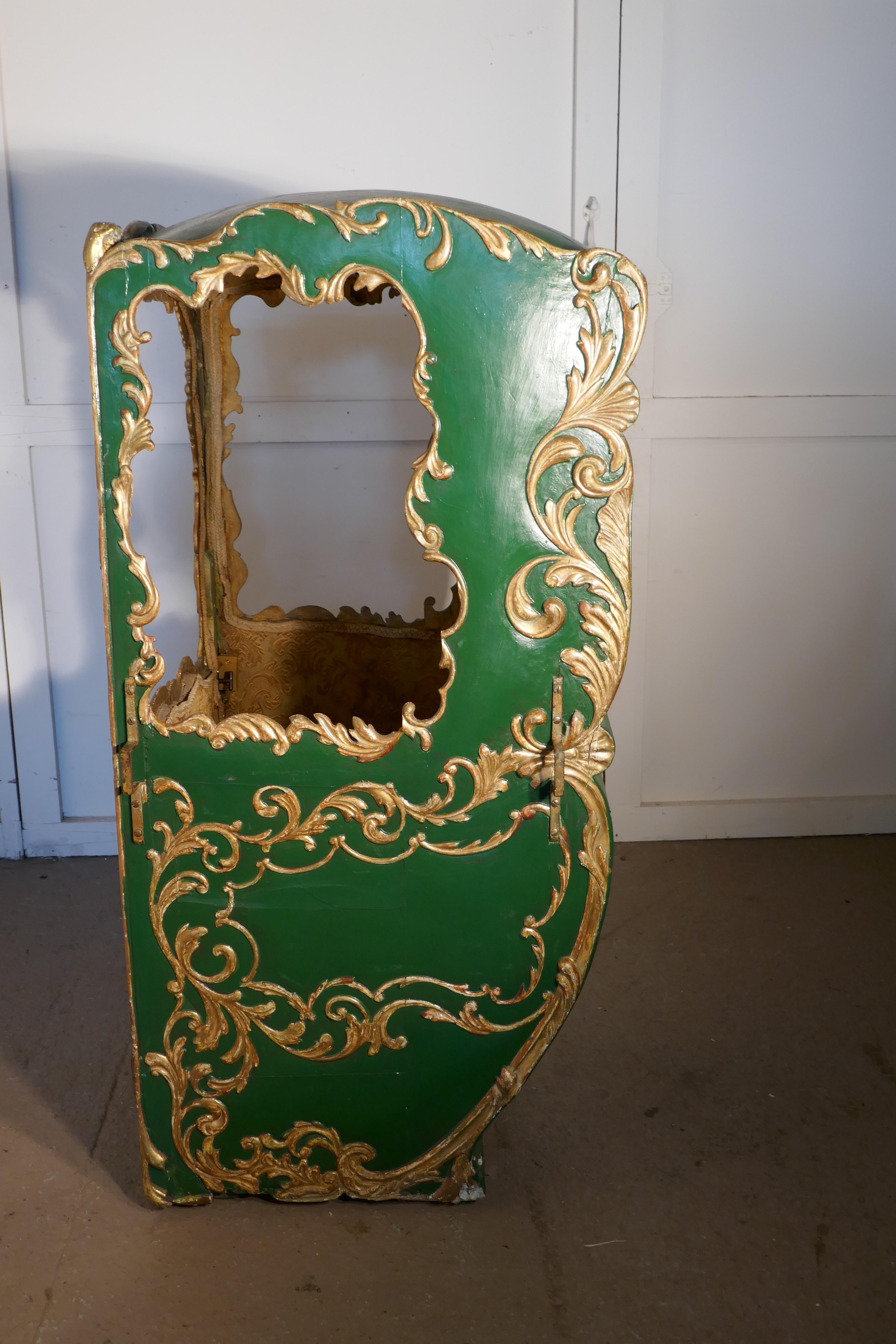19th century Italian Sedan chair 

This is a mid-19th century piece, it is the Rococo style, in Green and Gold and upholstered inside in a heavy gold brocade, complete with cushion on the seat
The chair has an outward opening door and side