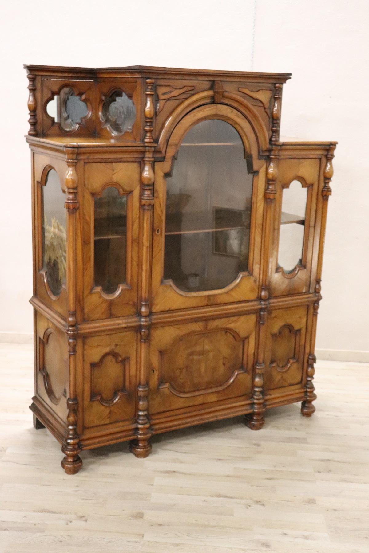 Antique Italian vitrine 1880s in solid walnut wood of a beautiful antique patina! Large internal useful space. Beautiful majestic line. Beautiful and fine antique glass. On the front splendid turned columns. Glass also on the sides to show your