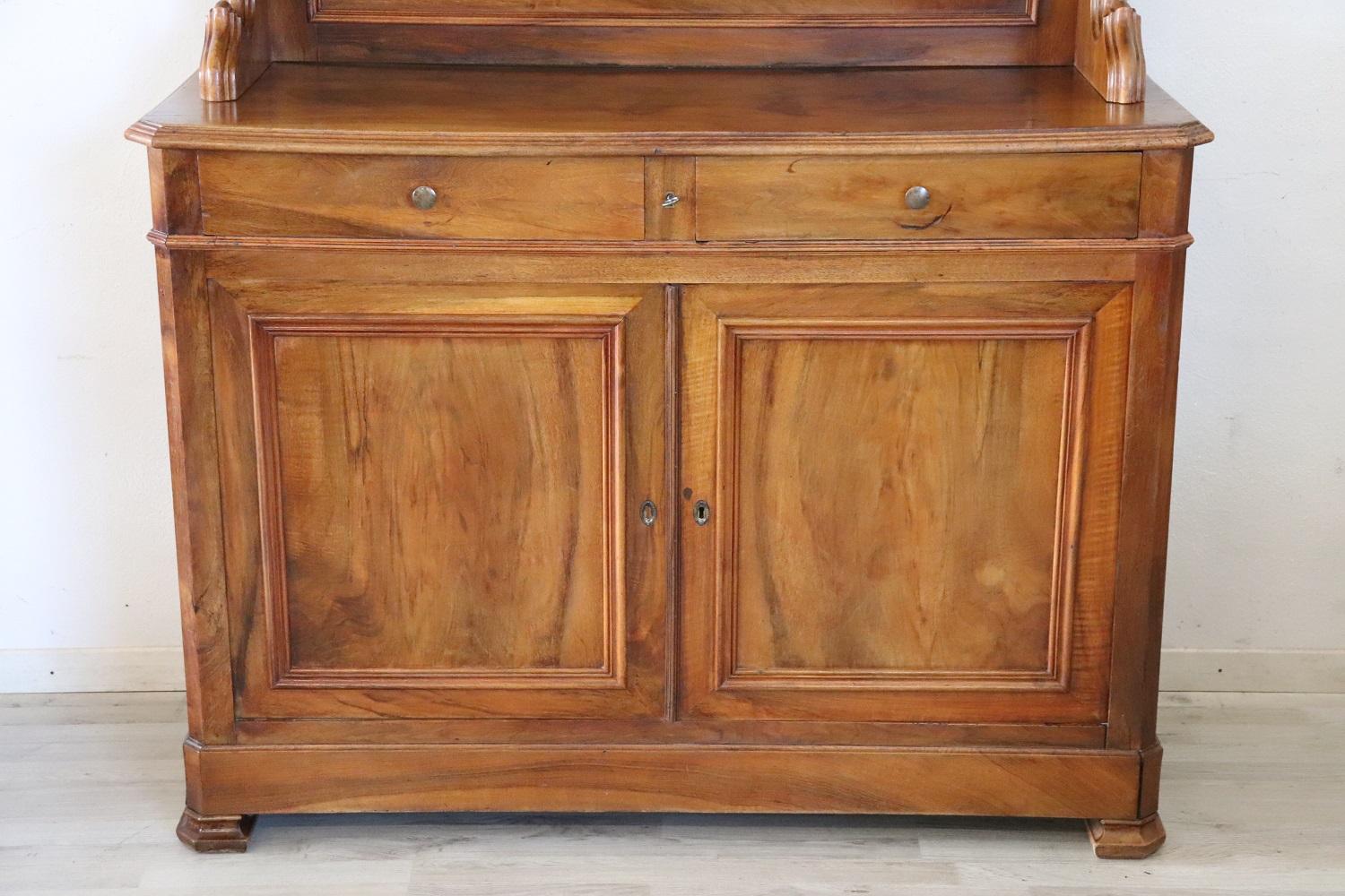 Antique Italian sideboard 1850 in solid walnut wood of a beautiful antique patina! It is divided into two parts for a practical transport. Equipped with two shelves in the upper part and one in the lower part. The shelves can be moved to the desired