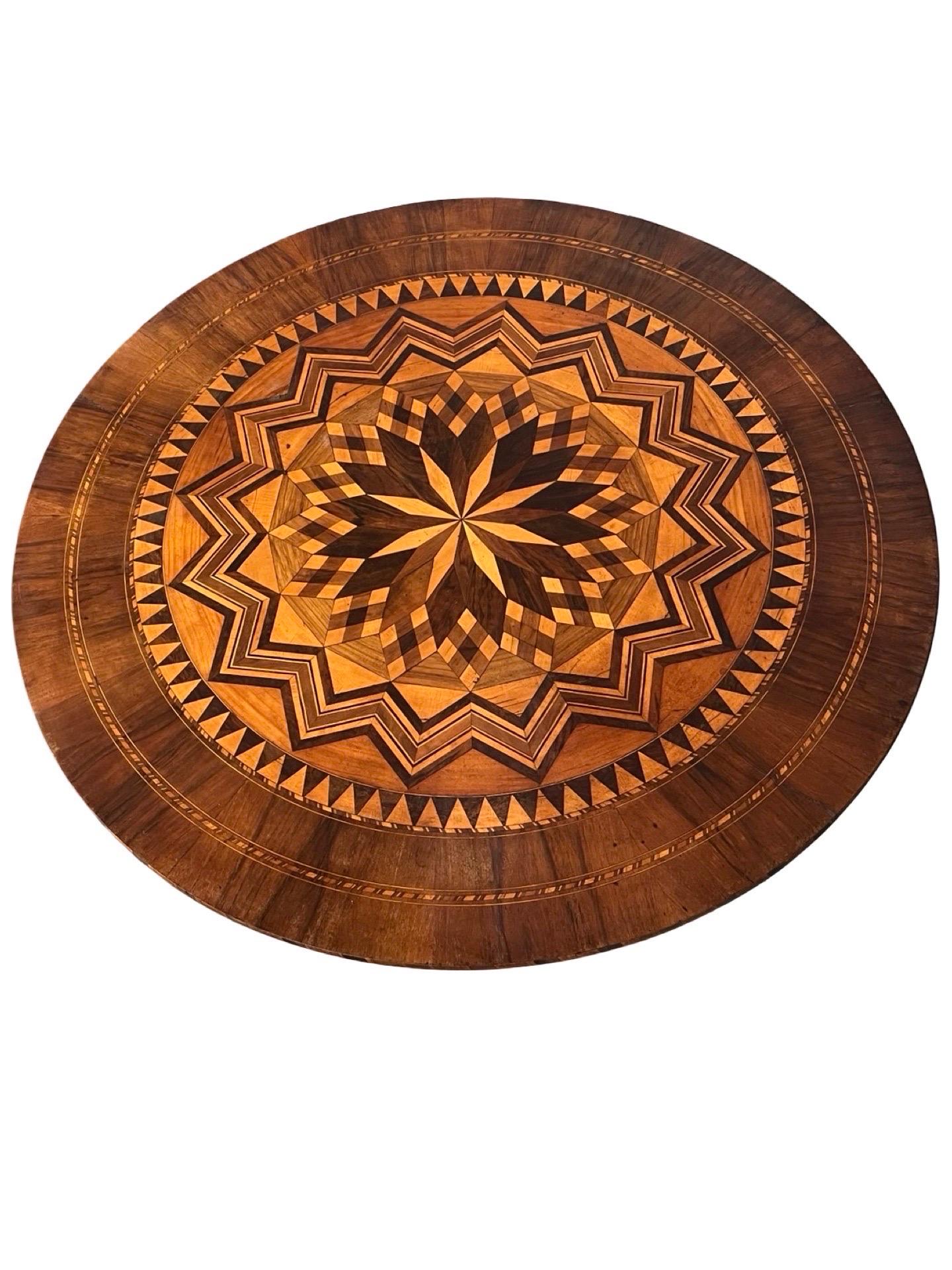 Table d'appoint ronde Sorrento fabriquée à la main en Italie dans les  au début des années 1800 en utilisant du noyer. La table suit les canons du style avec des incrustations géométriques complexes à symétrie radiale sur le plateau et des motifs