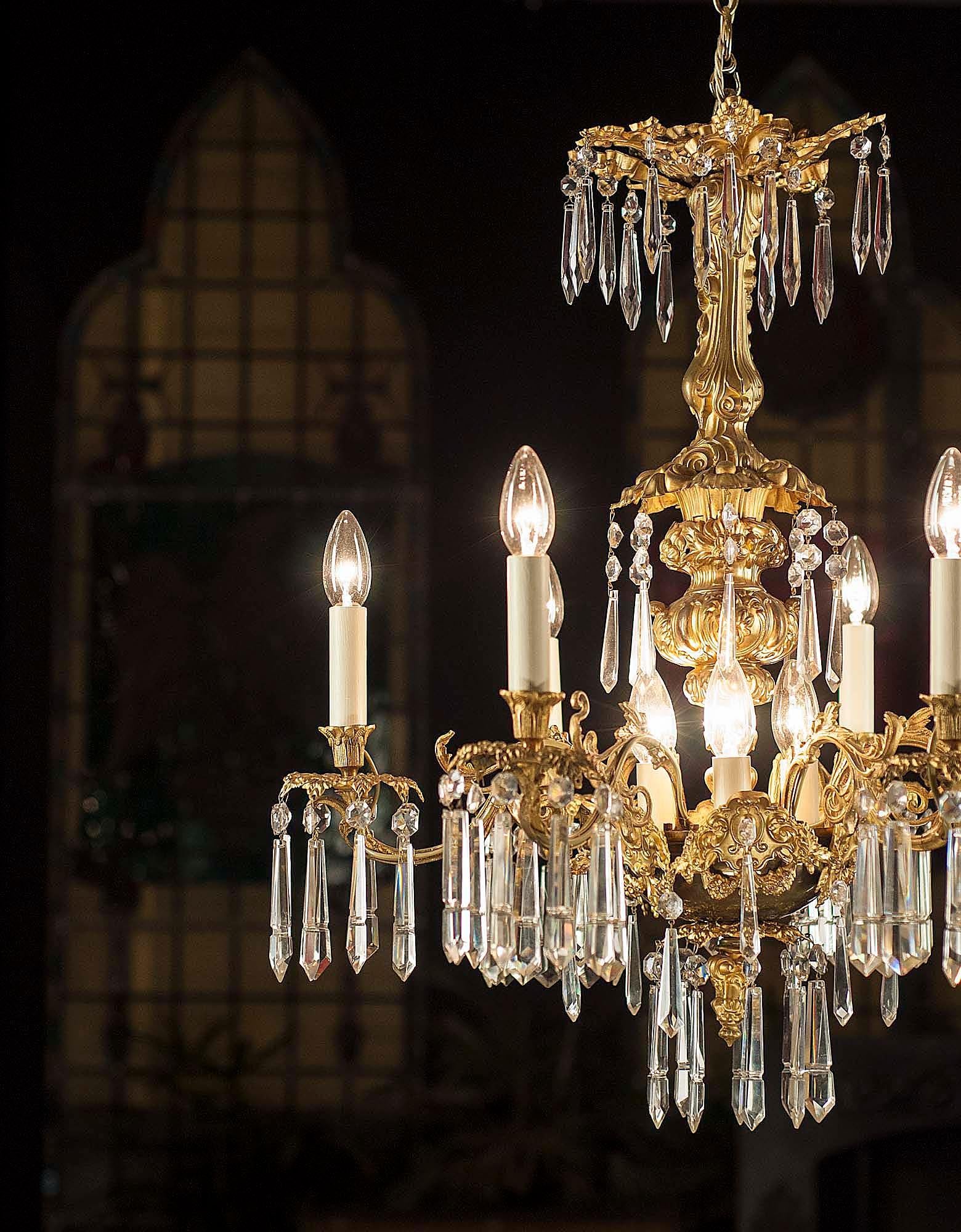 A 19th century Italian style gilt bronze chandelier, hung with six arms, each ensconced with cut crystal prism drops hung from numerous pierced drip trays. Converted to electricity,
mid-19th century.