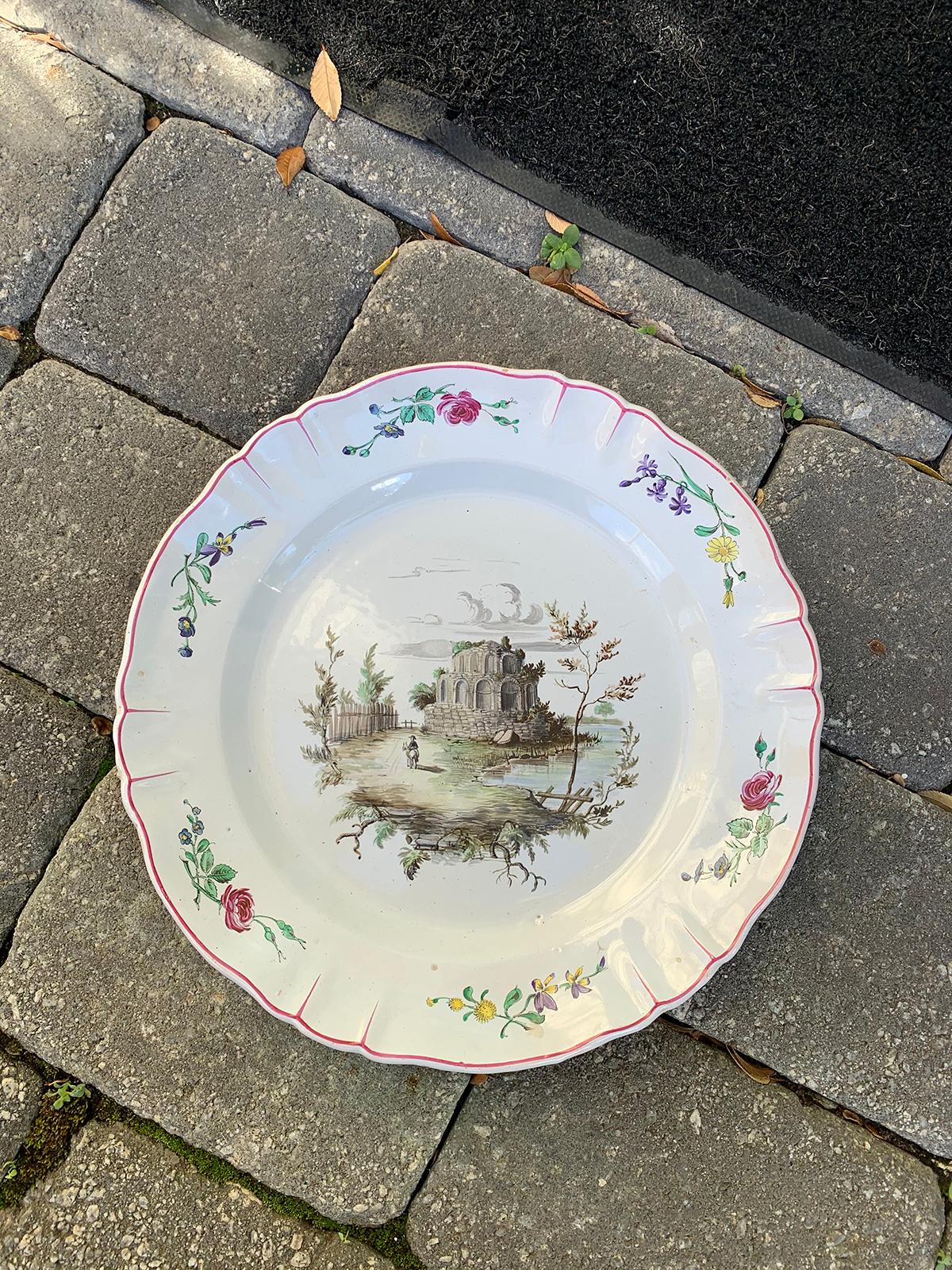 19th century Italian tin glazed white porcelain charger with neoclassical scene and floral border. Unmarked.