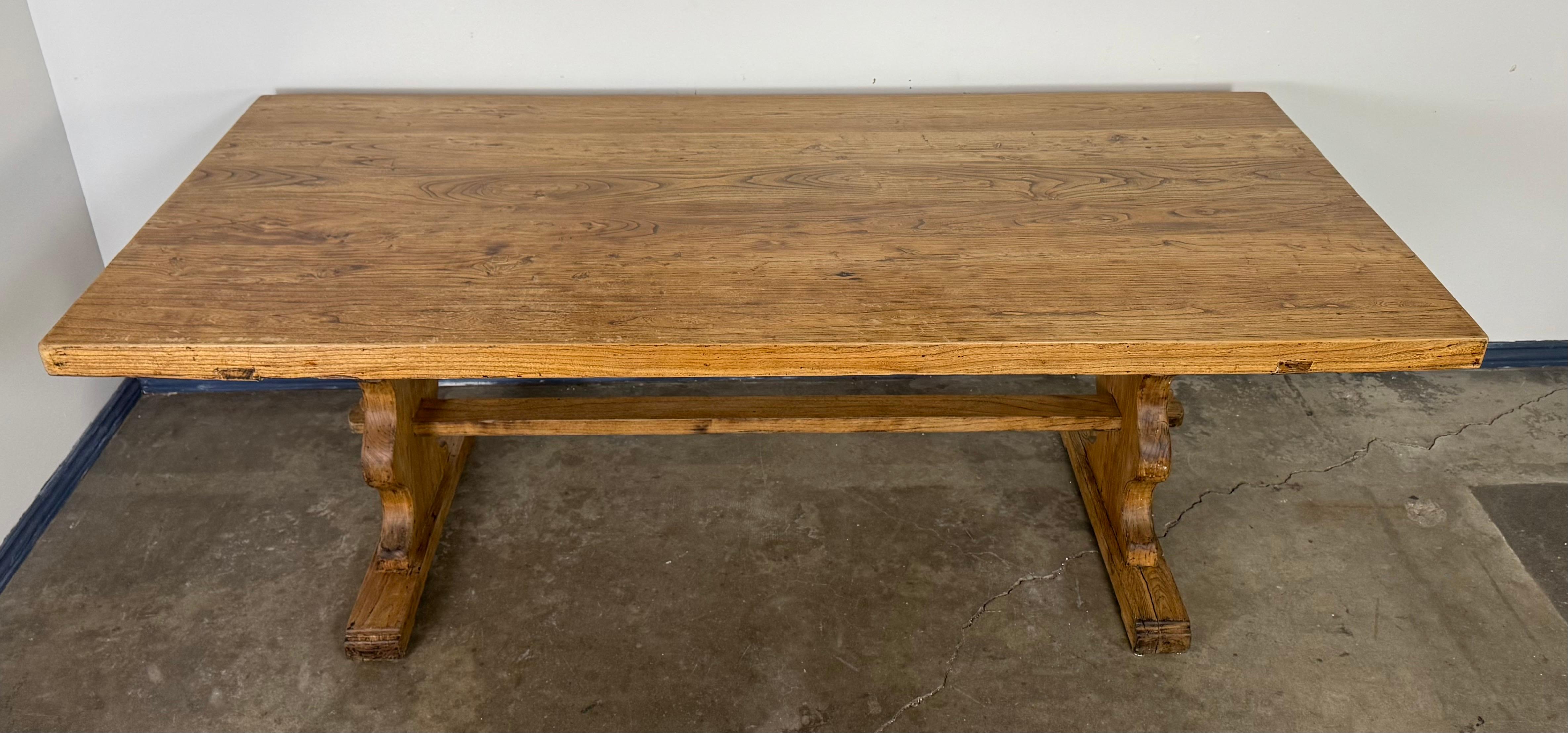 A handsome 19th century French Provincial trestle dining table handcrafted from solid oak. The rectangular top, constructed with thick planks of mellowed oak, exhibits a beautiful timeworn patina that speaks to over a century of use. Its clean,