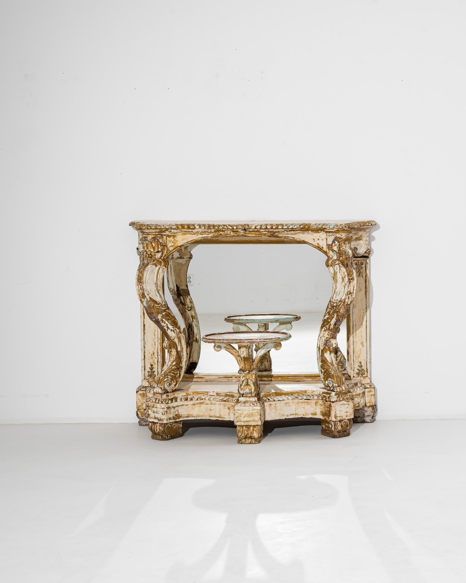 Elegant and mercurial, this antique wooden console table is a quintessential Rococo fantasy. Built in Italy in the 1800s, the form evokes grottos and fountains, a forest shrine overgrown by lush plants. The dramatic S-shaped curves of the front legs