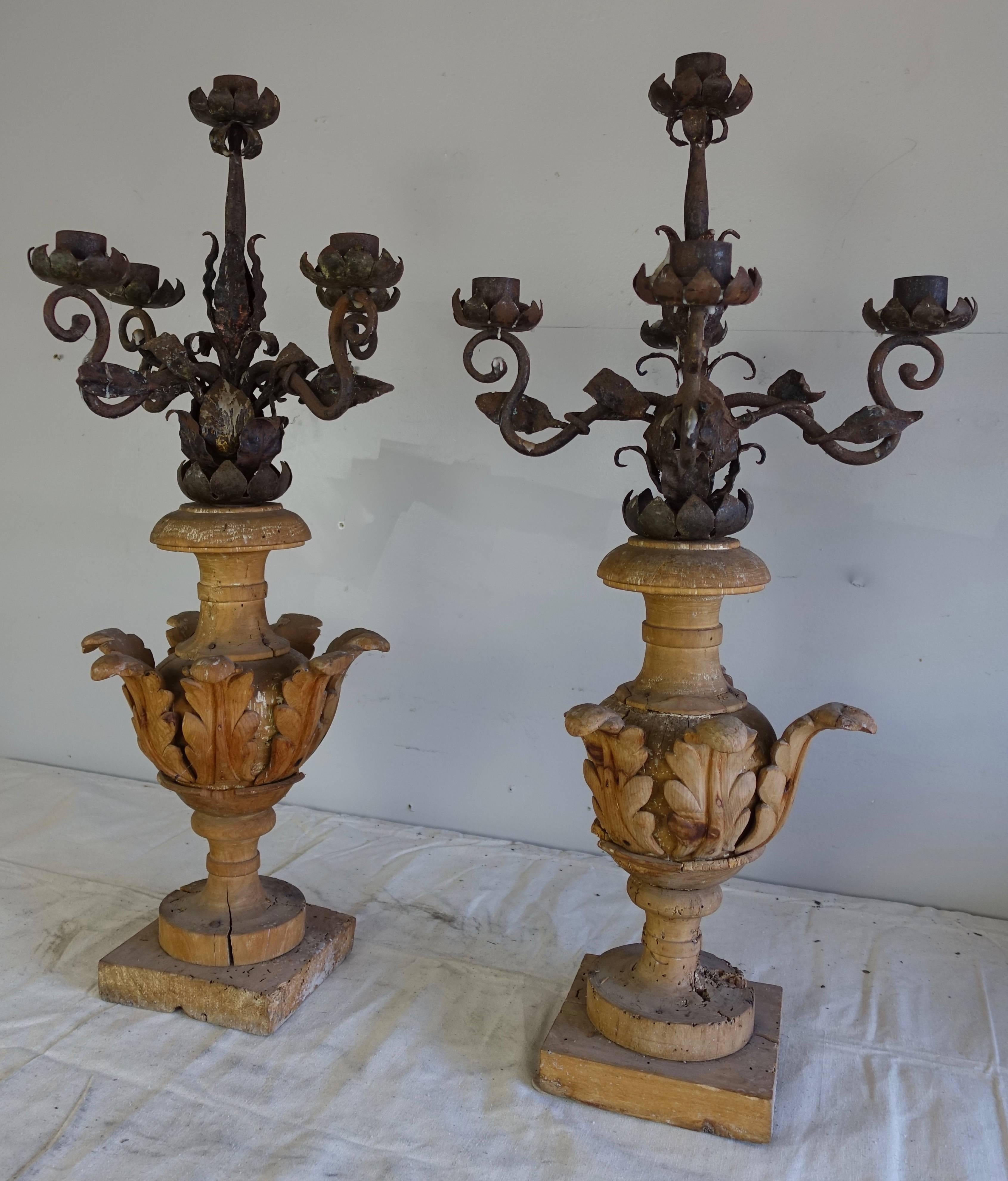 Pair of 19th century five-light Italian carved walnut and hand-wrought iron candelabra. The wood bases are composed of an urn of carved acanthus leaves that are filled with a bouquet of hand-wrought iron flower candleholders. They can simply be used