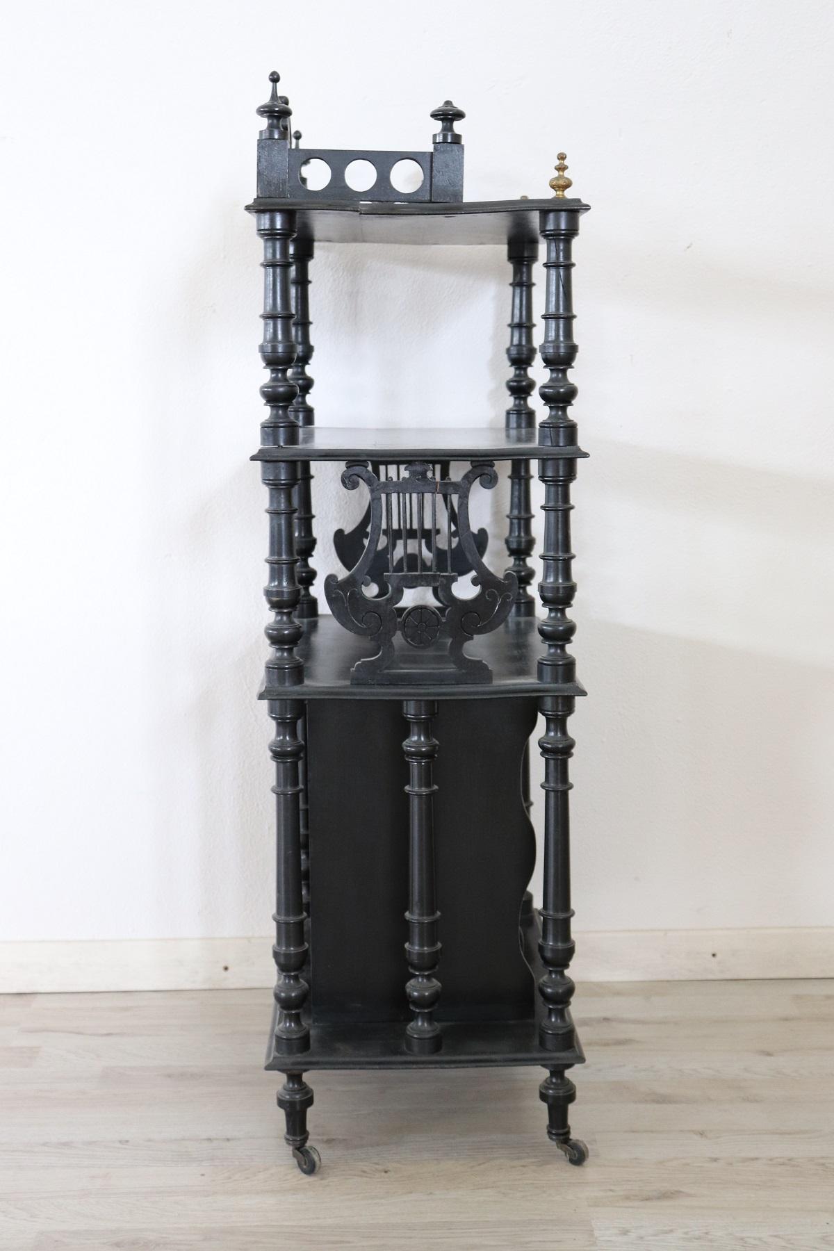 Beautiful antique étagère in ebonized walnut typical of the mid-nineteenth century with elegant turning. To the feet it bears typical nineteenth-century wheels. Ideal item as an object holder or a small bookcase. Used to report signs of wear. See