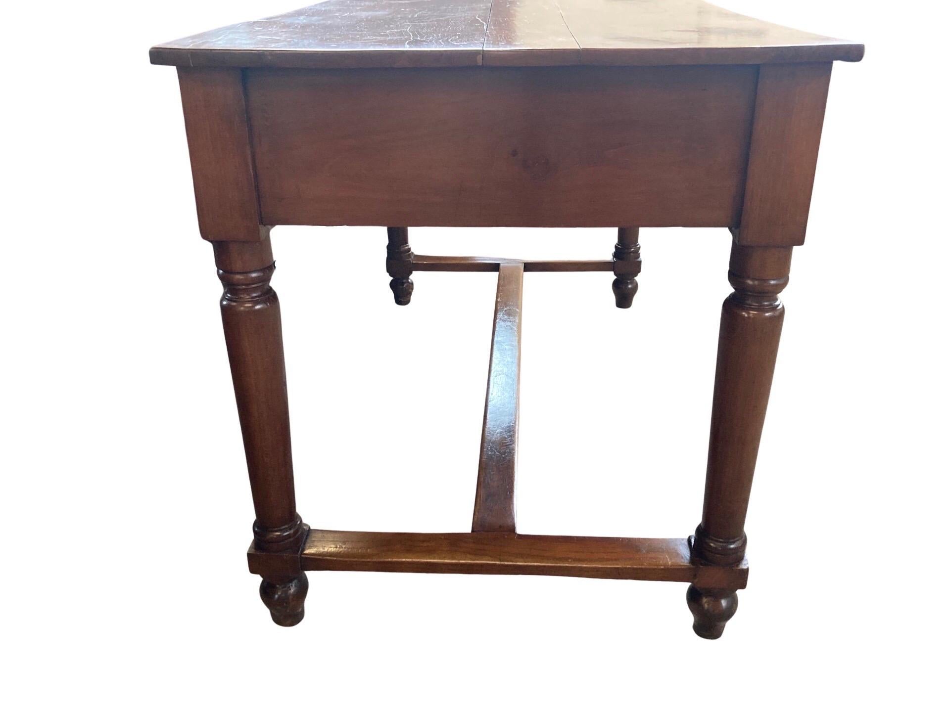Kitchen table hand-crafted in Central Italy in the early 1800s using walnut and pegged construction. The table has a beautiful warm, deep amber color and features a single drawer inset on the front of the flat apron. The drawer shows beautiful