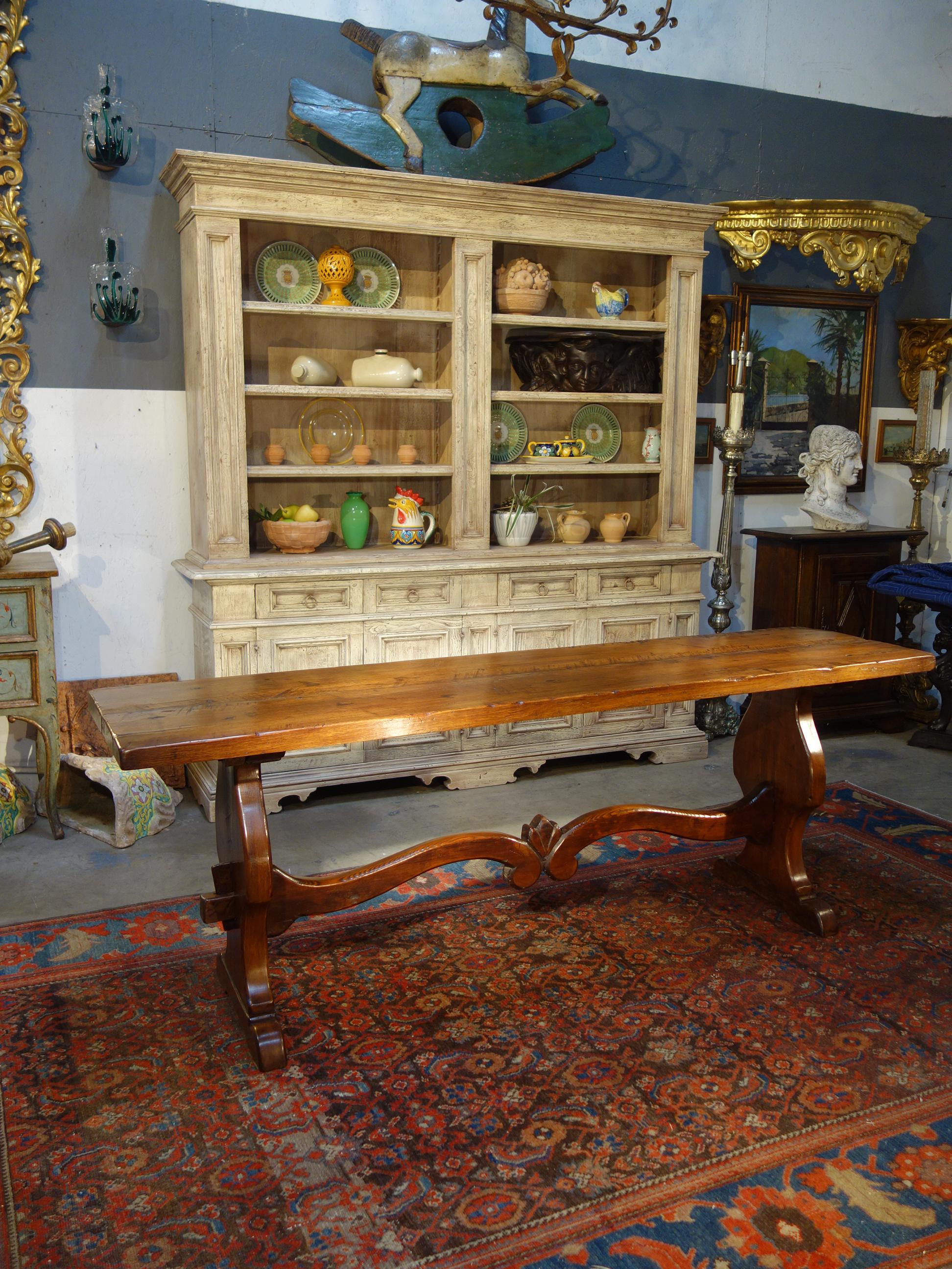 Majestic antique Italian refectory style console table with solid Italian Walnut 2-slab top and carved Frattino bases with cross stretcher, Circa 1840. Classic Renaissance shellac preservation finish & protective wax. Perfect for console, server,