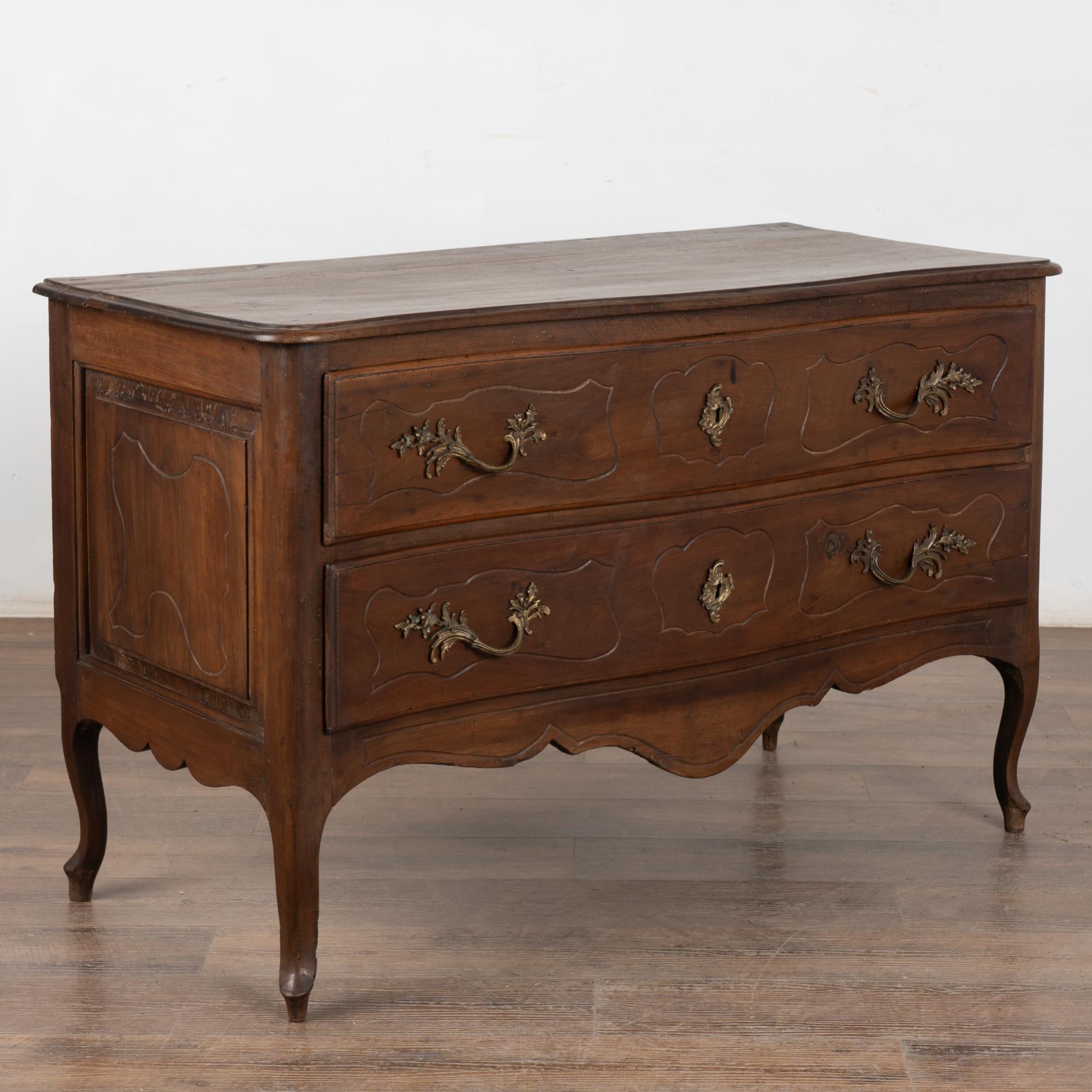 Grande cassettone in noce rococò italiano a due cassetti che poggia su gambe cabriolet rialzate.
Un semplice intaglio delinea i grandi tiranti in ottone e le chiavi di sicurezza di ogni cassetto, oltre alla gonna smerlata.
I cassetti funzionano,
