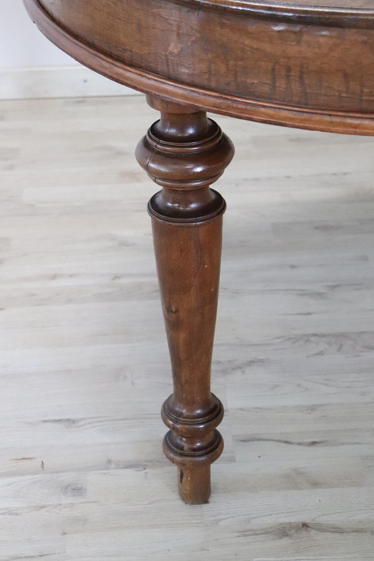 Beautiful important antique round dining room table, 1850s in walnut. This table is perfect for a dining room, it extends into the center becoming a large table that can accommodate many people. The four legs are in solid walnut wood. The original