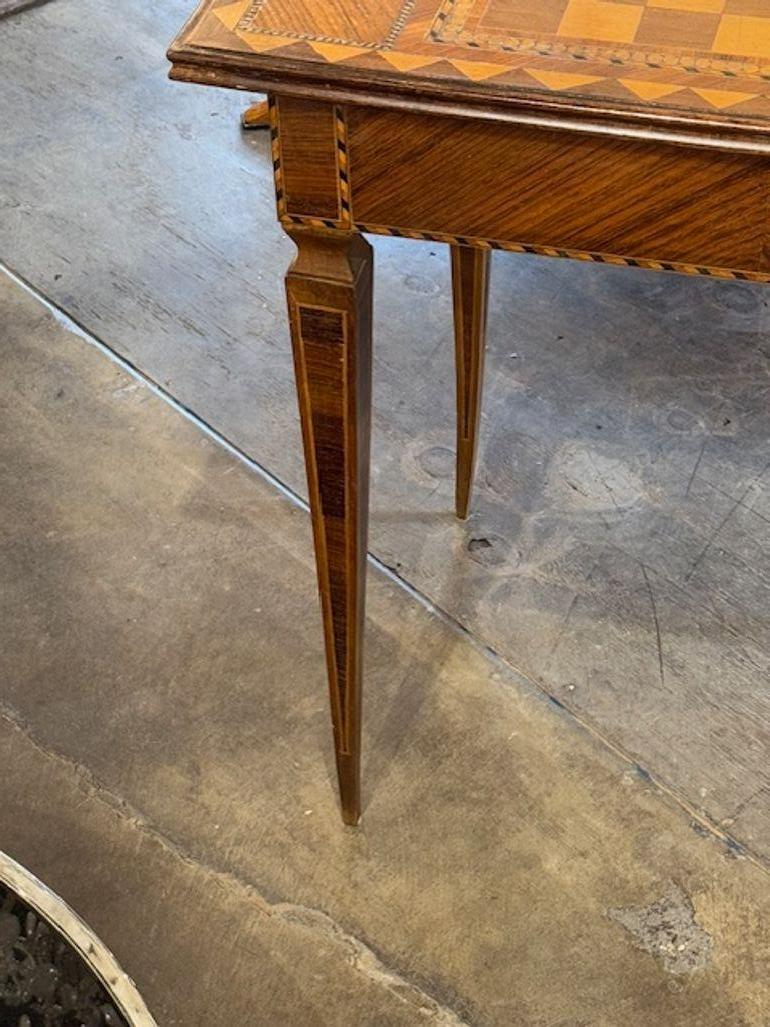 La table d'appoint en noyer italien du XIXe siècle présente un plateau en damier unique. Fabriquée en bois de noyer de haute qualité, cette pièce antique dégage un charme intemporel qui s'accorde aussi bien avec les styles de décoration