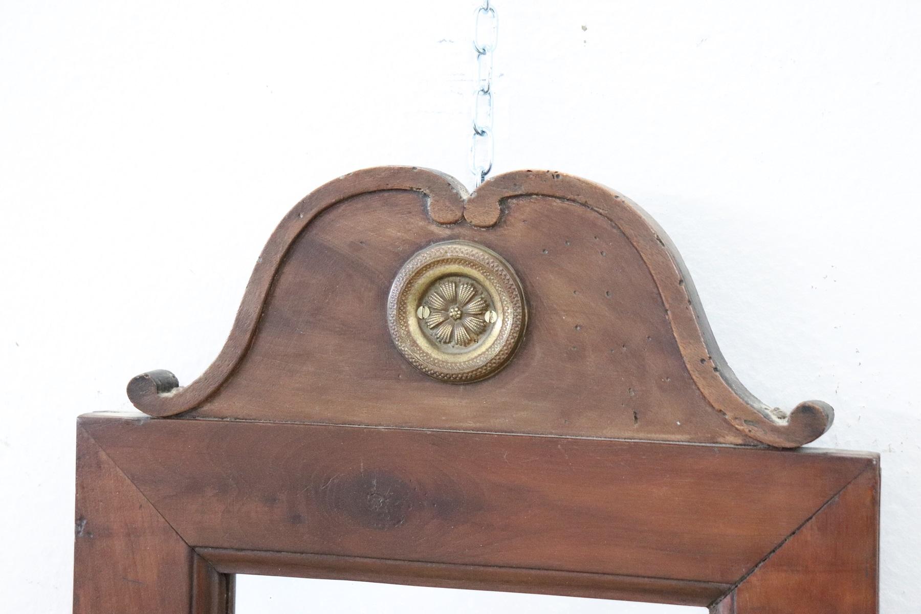 19th century Italian walnut wood wall mirror circa 1850s with refined decoration. Particular decoration with gilden chiseled bronze decorations. The mirror is antique to mercury so it presents imperfections look good at the photos. Perfect wood