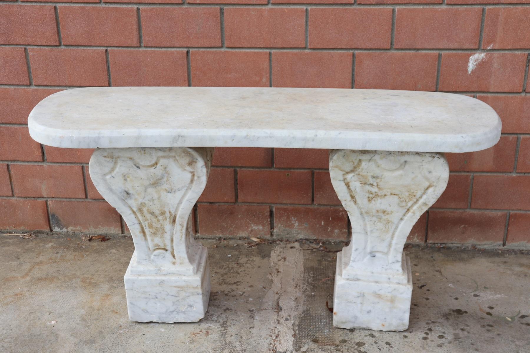 Beautiful refined garden ad outdoor bench. Beautiful and majestic in italian white Carrara marble. The bench has a refined classic decoration. The marble shows signs of the passage of time with some stains. This bench is perfect for embellishing an