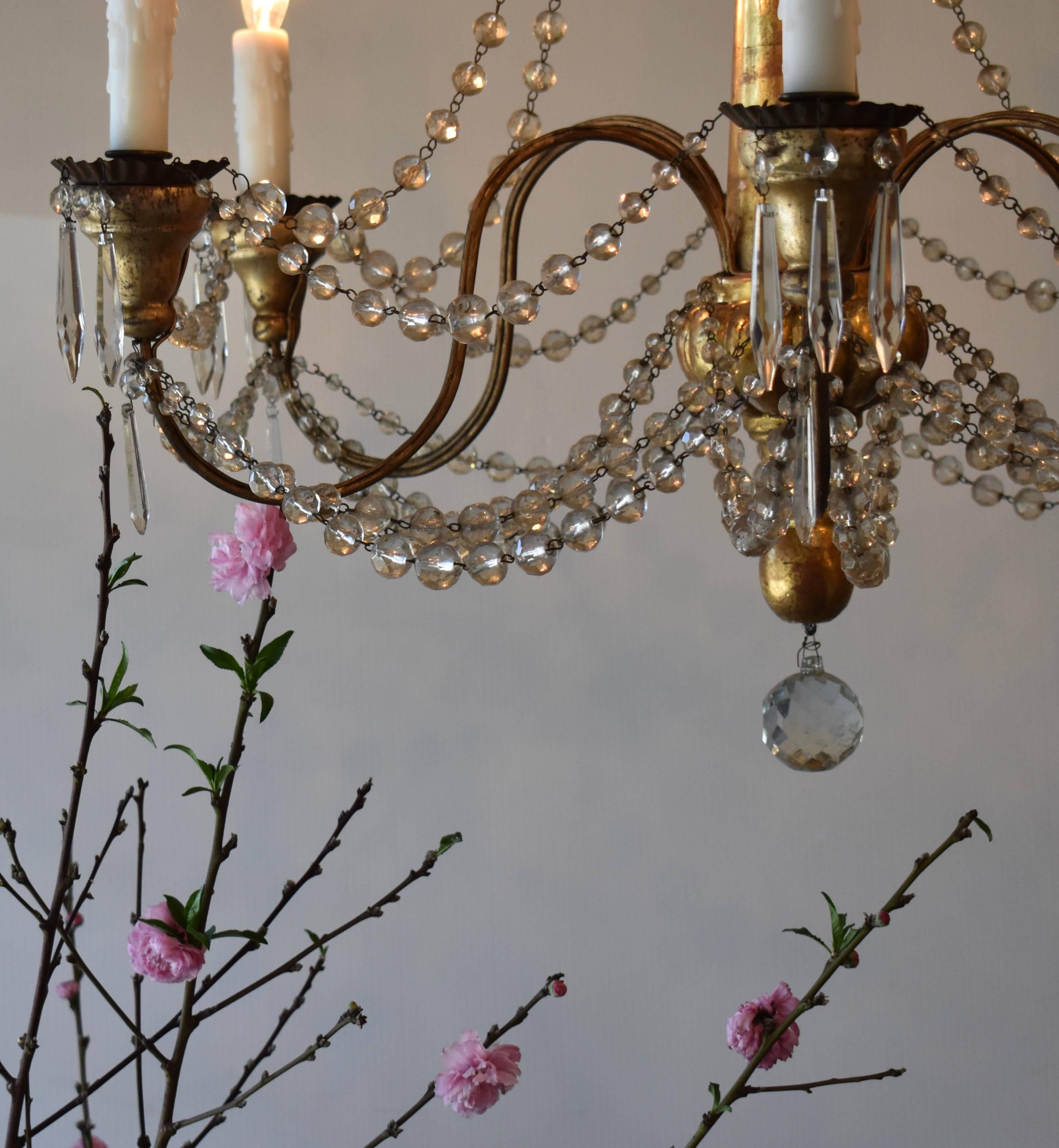 Elegant 19th century Italian gilded wood and crystal chandelier. Beautiful aged patina on the wood. All newly restored and wired. Height of 31