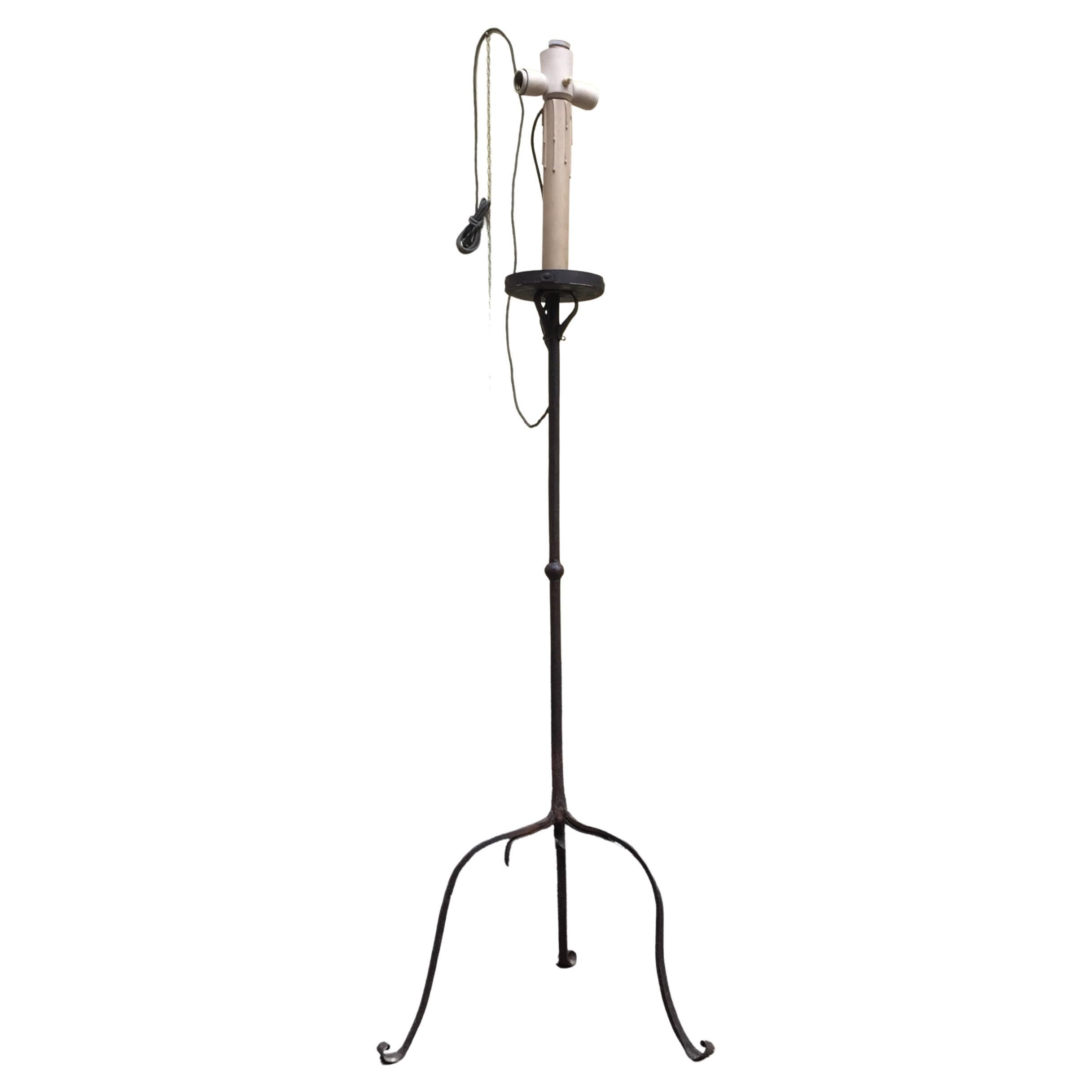 Antique Italian iron floor lamp, a linear circular wrought iron torchere dating back to the early 19th century. 
Striking elegant classical form and a lovely original patina, a knopped turned stem topped by a round pan, standing on a tripod base