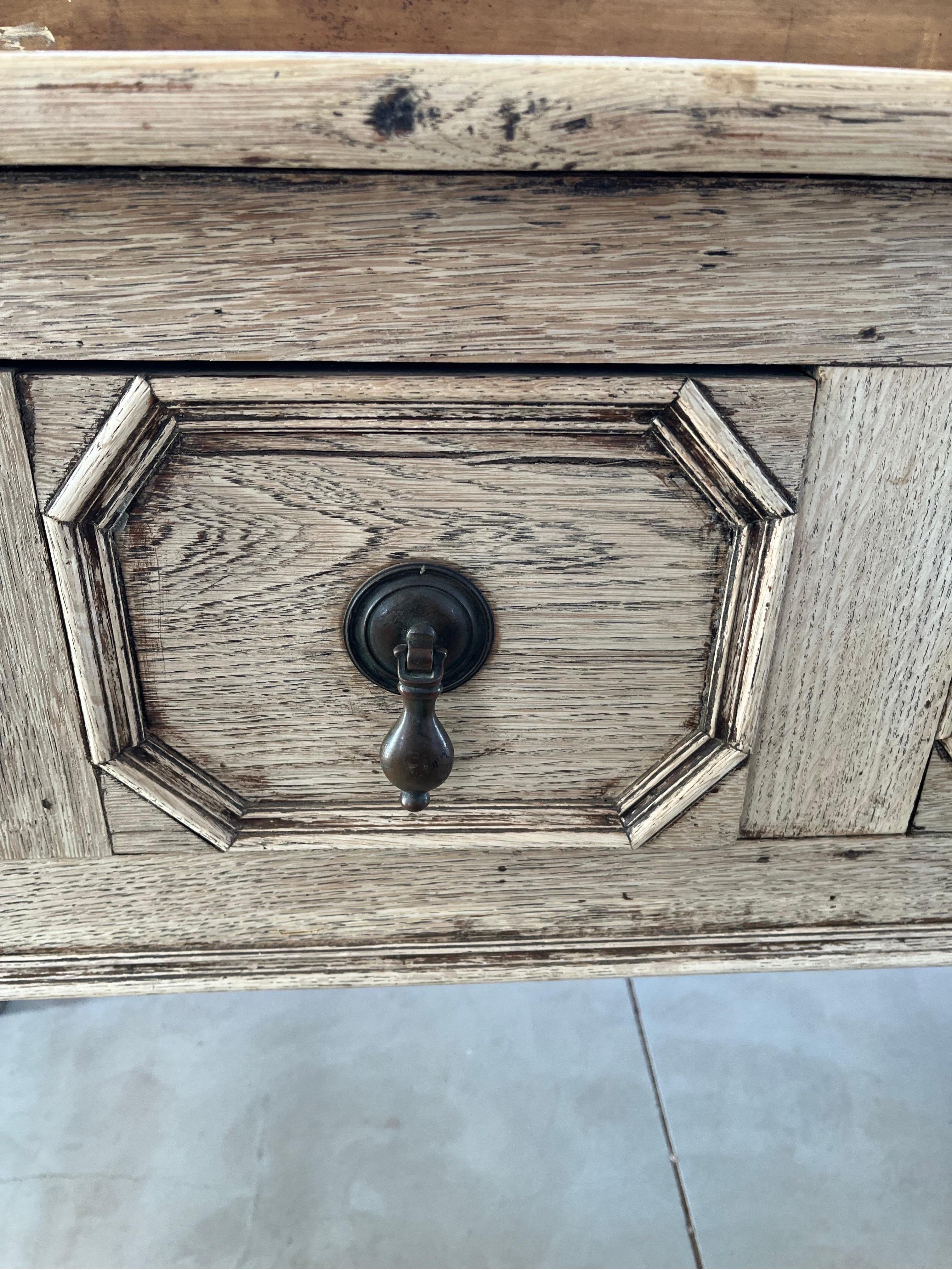 Jacobean-style console hand-made in the late 1800s using oak. The console shows the typical elements of the Jacobean style with drawer fronts decorated with geometric shape made with molding, and hand-turned legs. The top is made of two boards with