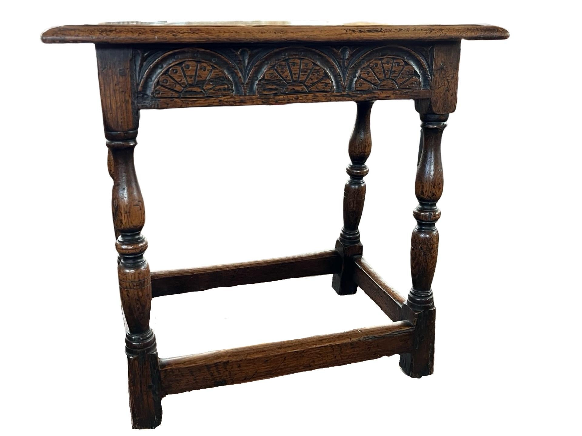 Taburete conjunto hecho a mano en Inglaterra a finales del siglo XIX con madera de roble y construcción de clavijas. El taburete tiene patas torneadas a mano unidas con un bastidor de caja. La parte superior es de una sola tabla con bordes