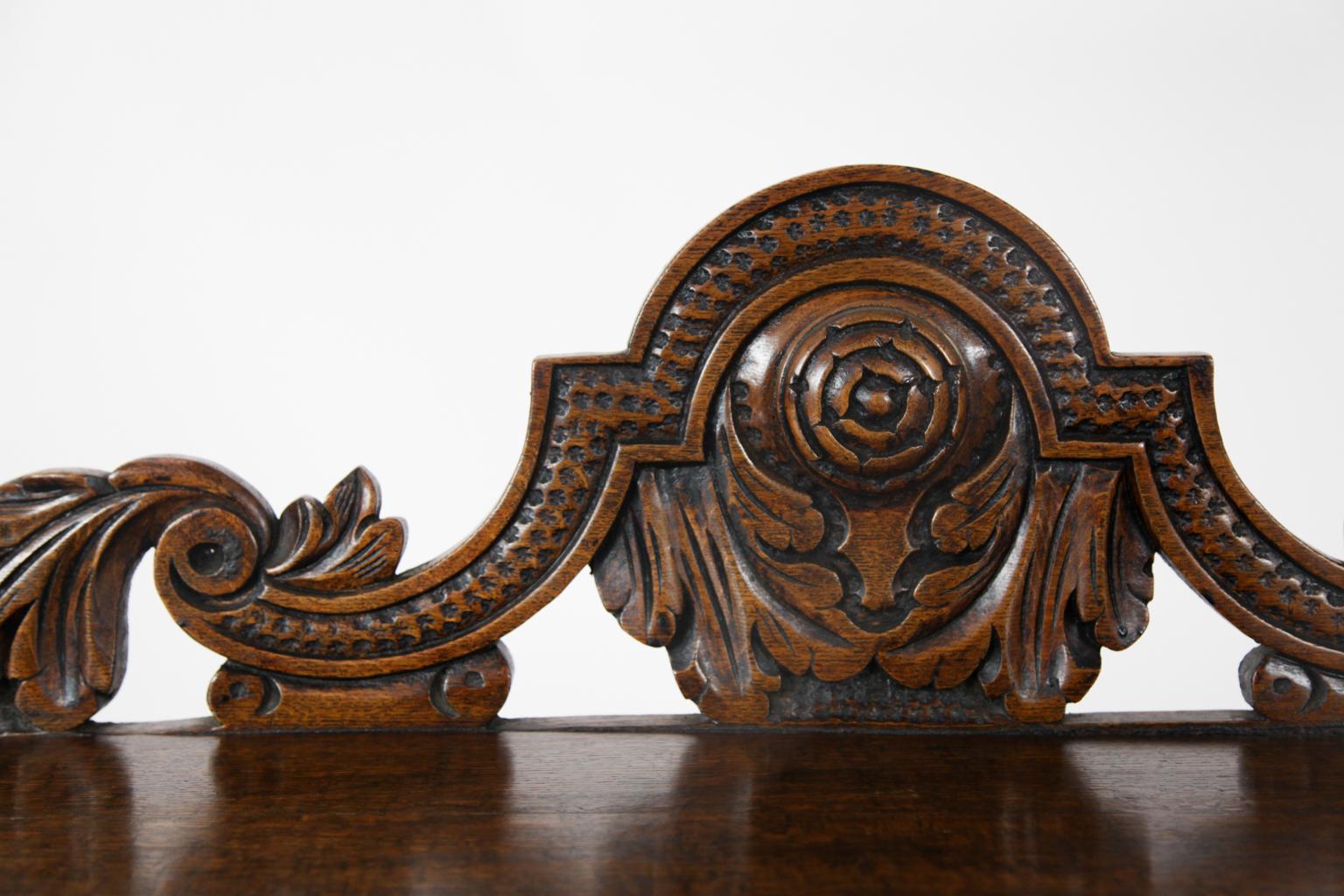 19th century Jacobean Revival carved oak side table, carved top molding and frieze, with carved and bobbin turned front legs, pilaster back legs, with elaborately carved gallery featuring floral swags and center medallion.