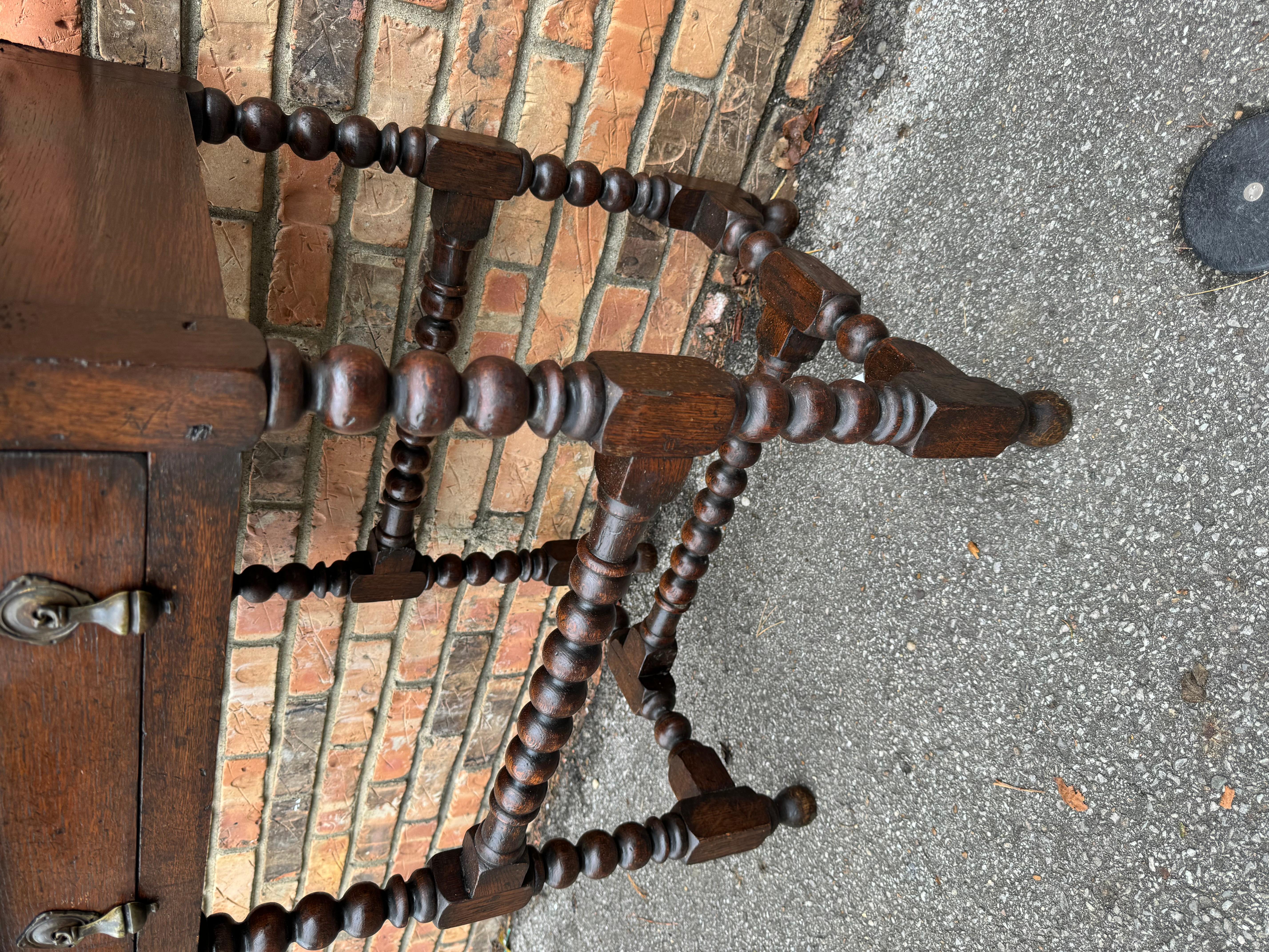 This gorgeous Jacobean side table has a beautiful rich finish and bobbin turned leg. The drawer features 2 beautifully aged brass toggle pulls. It retains its original brass makers label from Thomas Clarkson & Sons.
This fine table would make a