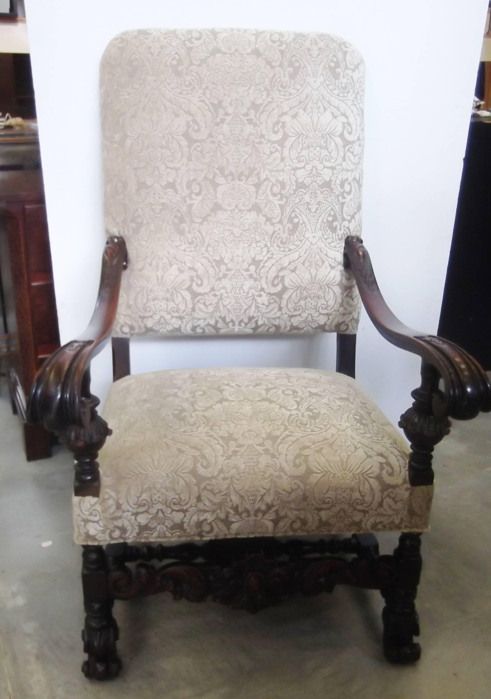 Impressive and stately English throne armchair with shapely scrolled arms. The detailed frame is hand-carved and has a nice patination to the wood from decades of well cared for use. The new fabric is a damask chenille in a neutral mushroom color.