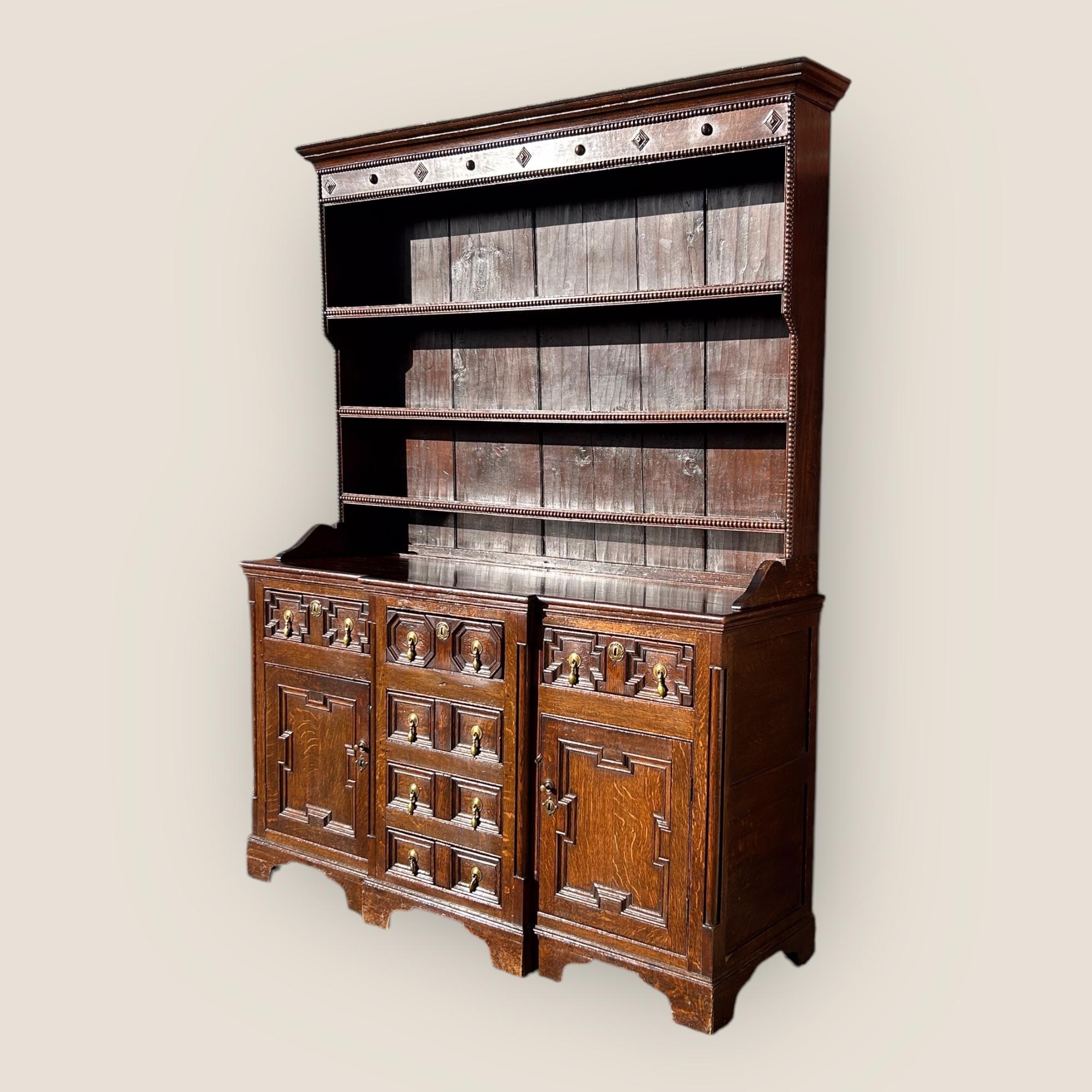 Ecco un comò in rovere in stile giacobino del XIX secolo con 6 cassetti con maniglie in ottone e 2 armadi. Il piano del comò presenta intagli e 3 ripiani.