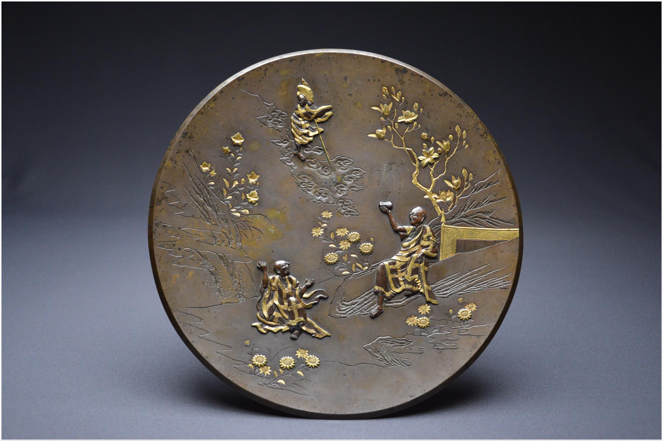 Japan
Meiji period (1868 – 1912)
Copper alloy with brown patina and gilt highlights
26.8cm
Metal weathering
Former French private collection

Japanese circular bronze dish with engraved decoration of a bucolic landscape and three ahrats