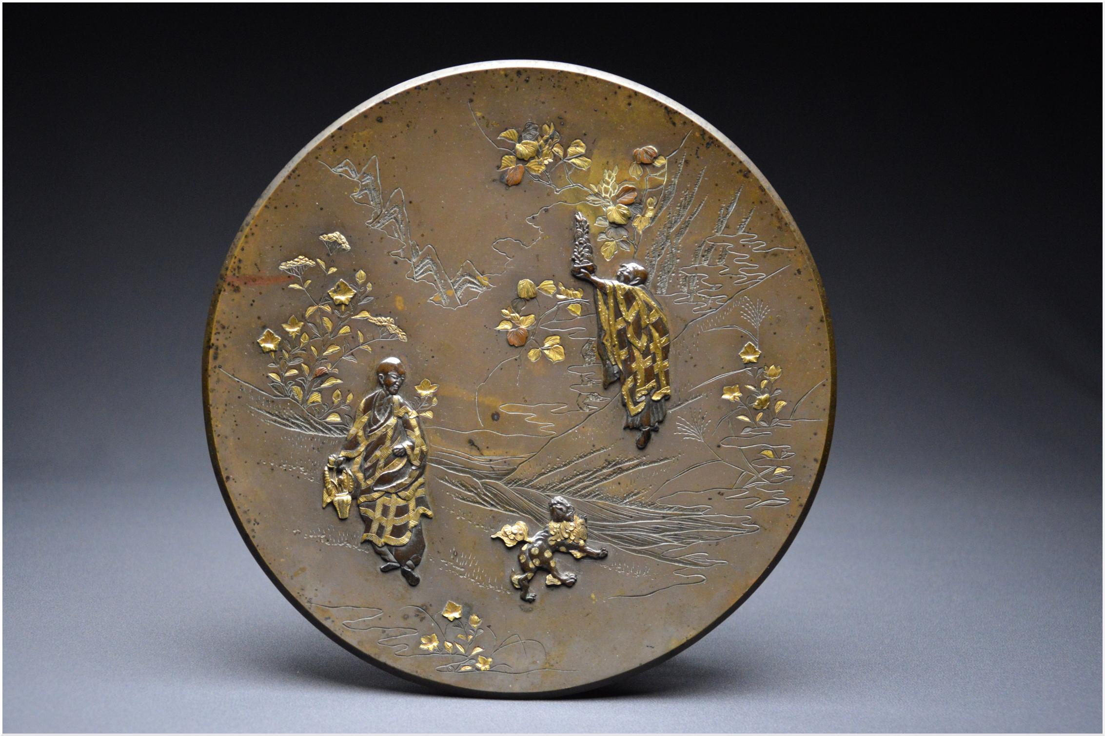 Japan
Me iji period (1868 – 1912)
Copper alloy with brown patina and gilt highlights
26.8cm
Metal weathering
Former french private collection

Japanese circular bronze dish with an engraved decoration of a bucolic landscape as well as a sishi