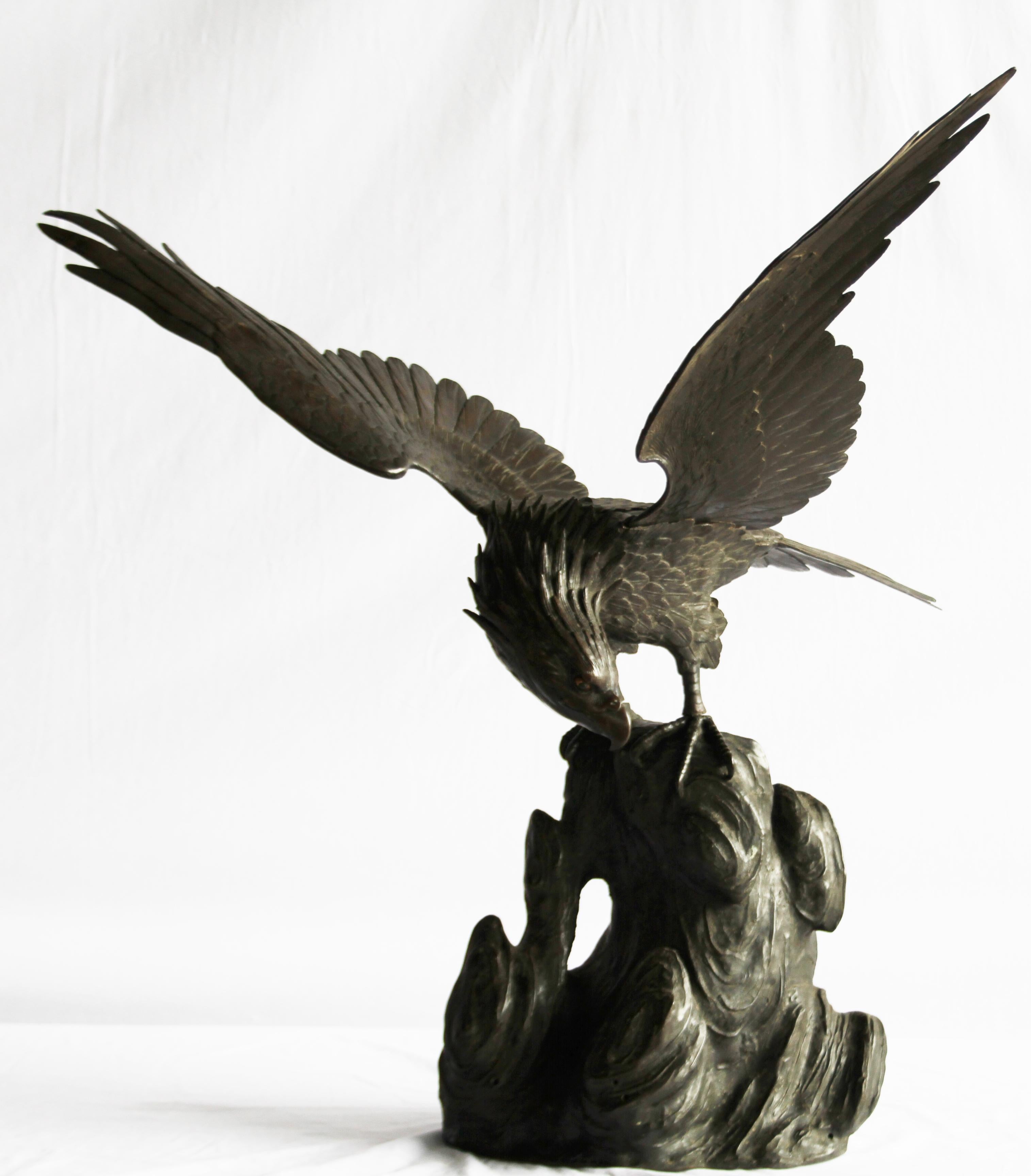 An impressive Japanese bronze statue of an Eagle. Meiji Period, 1868-1912. Of dark brown patination. Realistically cast and tooled with plumage. Shown without stretched wings (detachable) and on stylised rocky base.