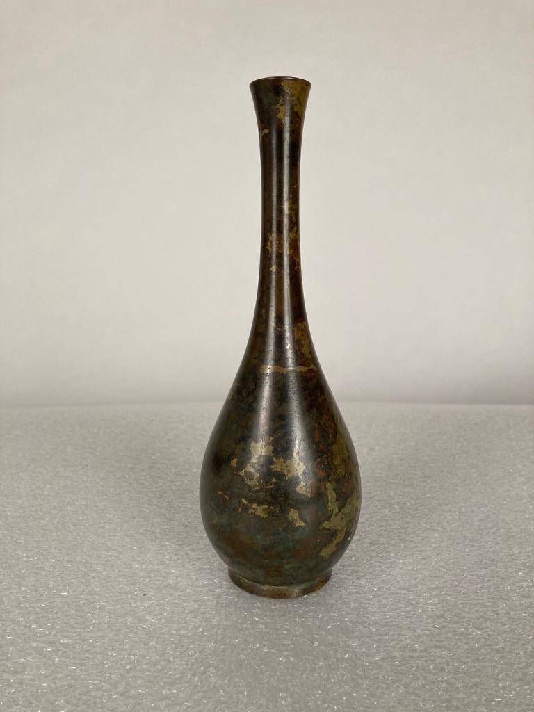 A small scale Japanese bronze vase of classic teardrop form with a wonderful variegated patina in gold, copper and brown. Perfect for a single rose or as a cabinet or table top decoration with a lovely silhouette. 
Measures: 9 inches high.
