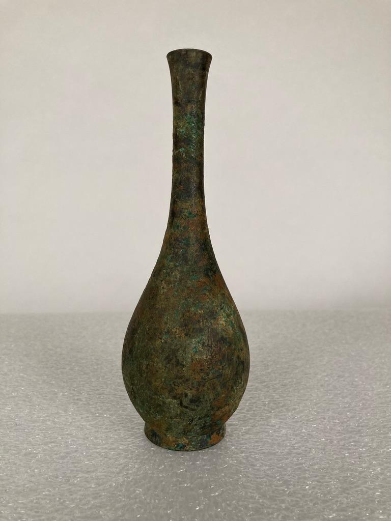 Elegant Japanese bronze vase in the classic tear-drop form with beautiful verdigris encrusted surface. An antique item with a very modern feel, a singular accent piece for a shelf, cabinet or meditation room. The perfect receptacle for a single