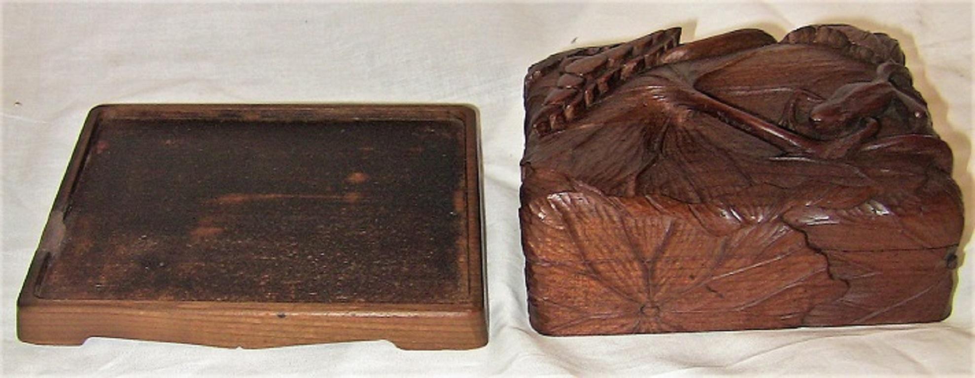 Presenting a glorious piece of Japanese carving and treen from circa 1890.

This is a lidded wooden box, on a stand, made of what appears to be camphor wood. A hardwood native to Japan.

The carving is Exquisite on this piece. The box is carved