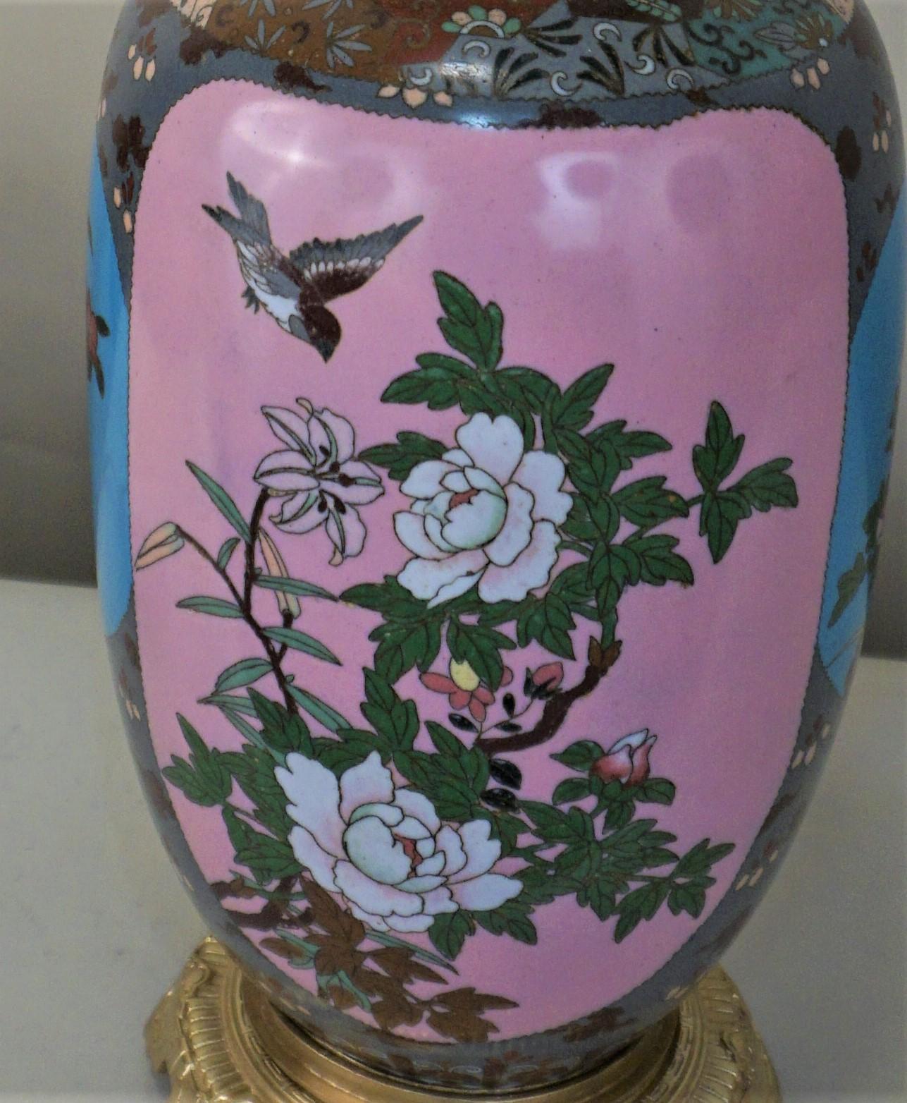 A 19th century cloisonné enamel vase oil lamp decorated with two panels enclosing either a bird and flower and bronze mounting hardware.
Electrified with one 3 way socket and fitted with handmade silk lampshade.
Total height including the shade is