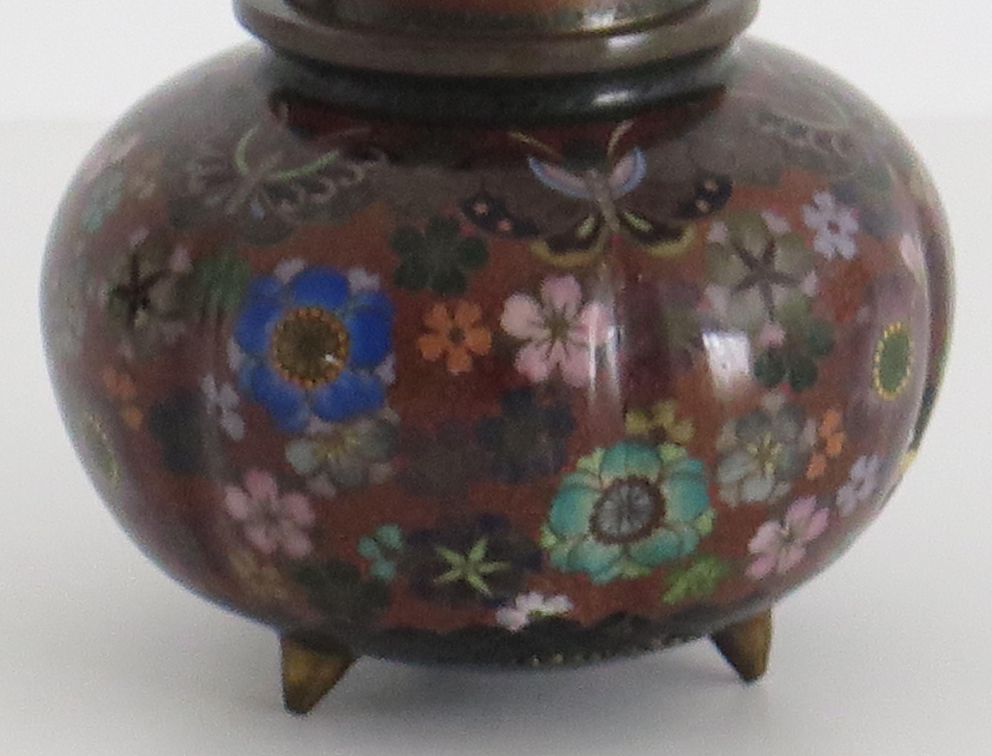 This is a very decorative cloisonné lidded jar, made in Japan and dating to the 19th century, early Meiji period, circa 1875 or possibly earlier.

The jar has a good shape of a compressed globular form with a short neck and standing on three short