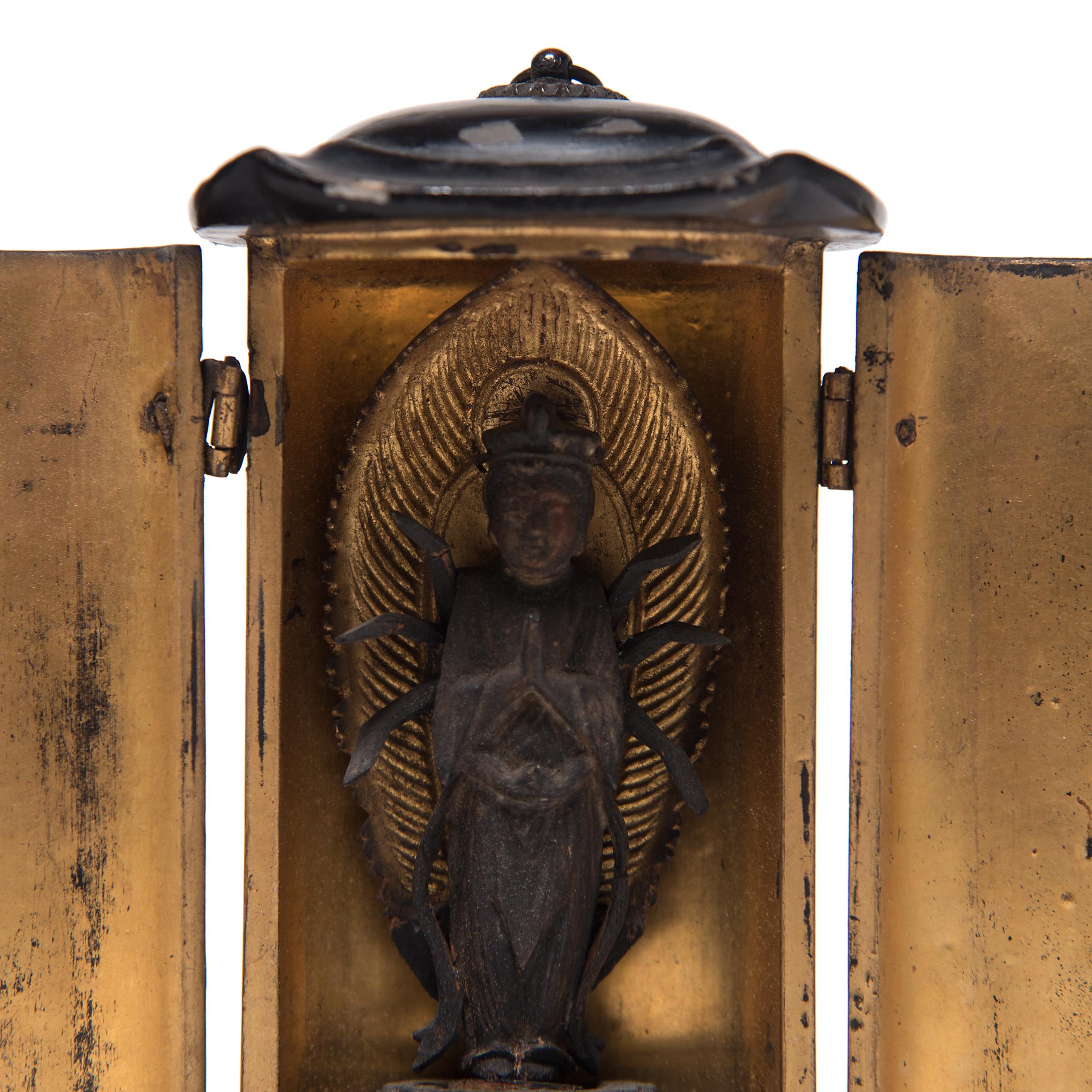 The simple exterior of even black lacquer that encases this traveling shrine belies the splendor within. The hinged doors open to a gilt interior framing the central figure of a resplendent Bodhisattva. Made in the 19th century, this petite Japanese