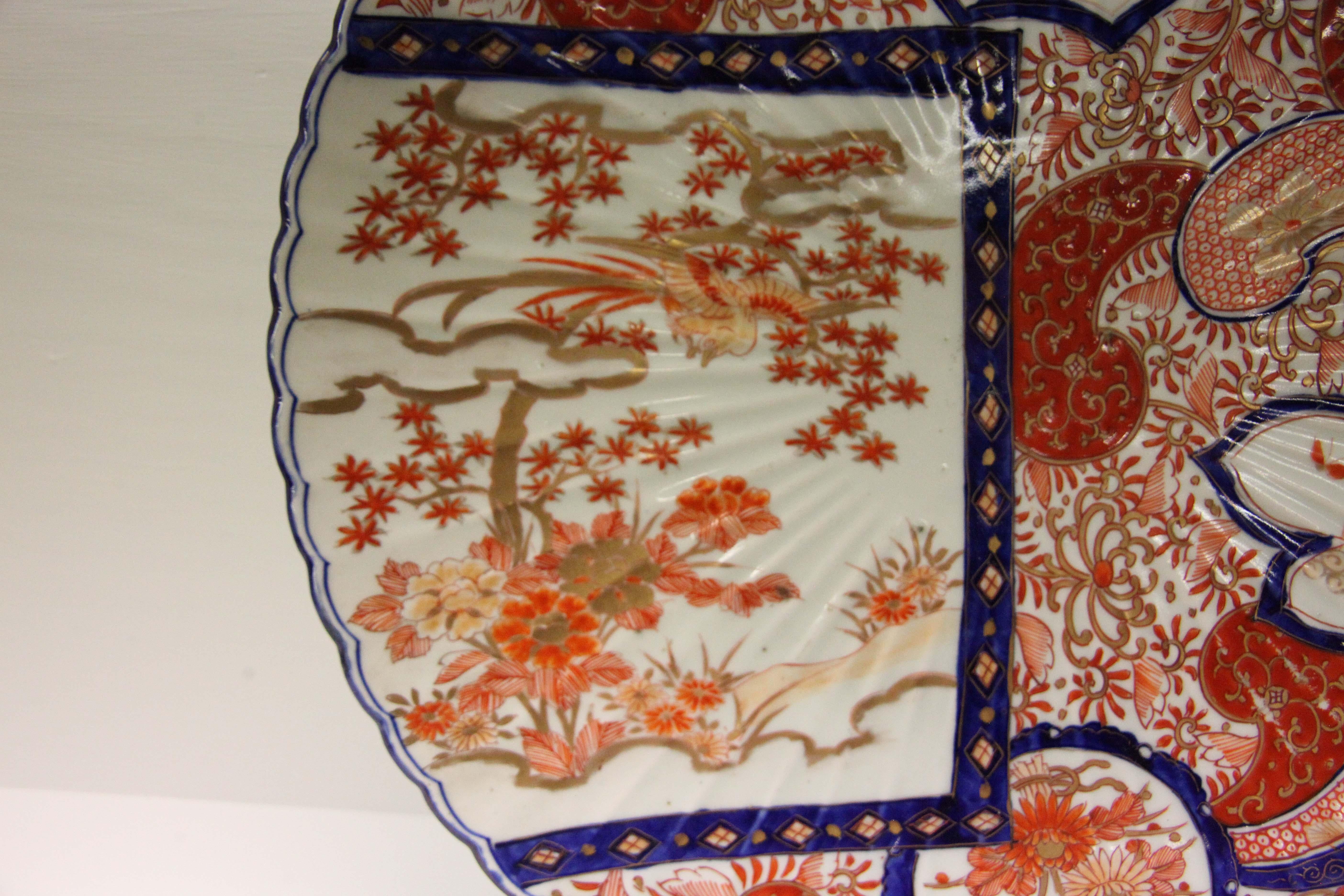 19th century Japanese Imari charger with scalloped edge, all-over floral pattern interspersed with multi shaped panels filled flowers and dragonflies.