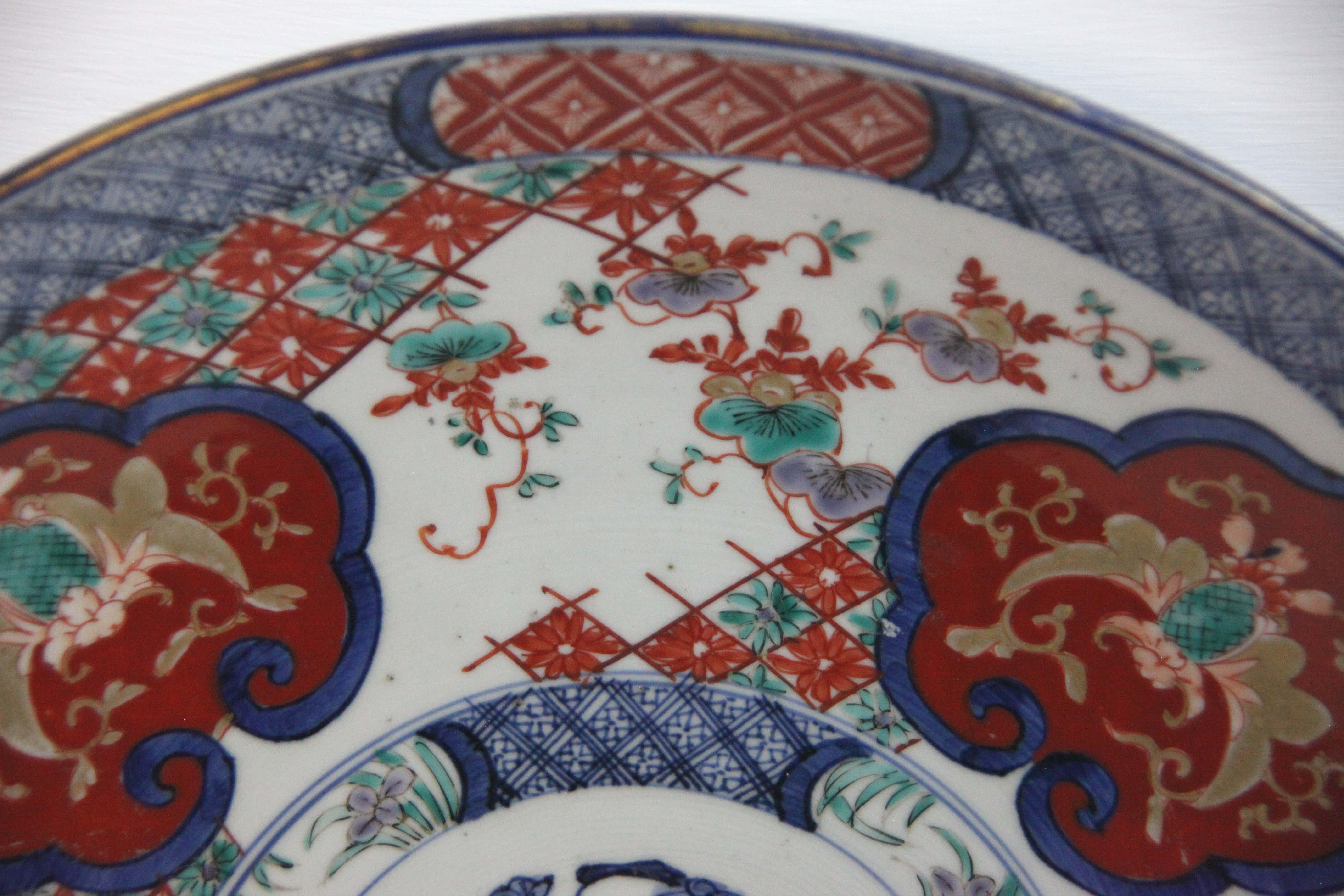 19th century Japanese Imari charger, with central medallion surrounded by stylized panels and floral work.