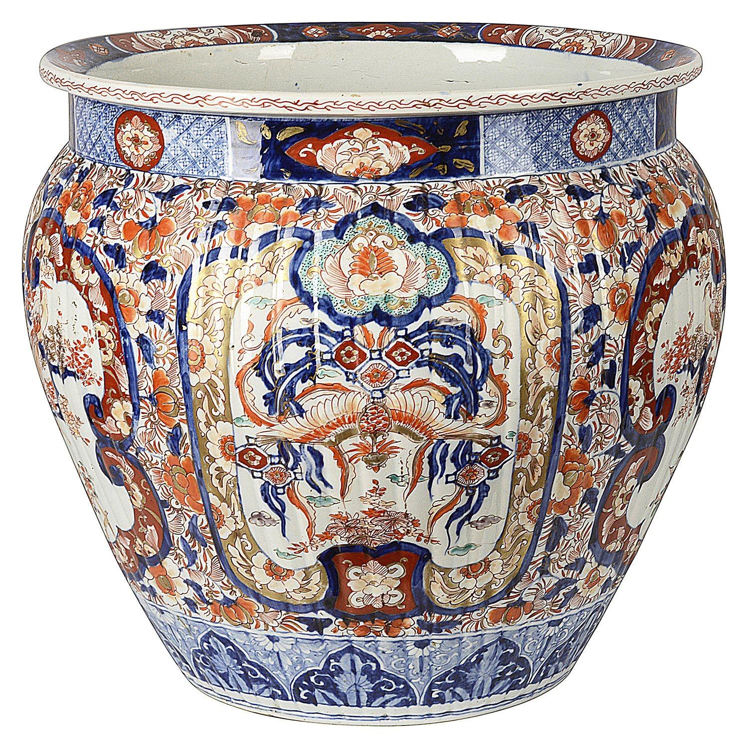 A good quality 19th century Japanese Imari porcelain jardiniere, having wonderful bold Imari colours of Blue, Orange and White. Depicting inset hand painted panels of exotic birds pirched in blossom trees, surround by classical oriental motifs and