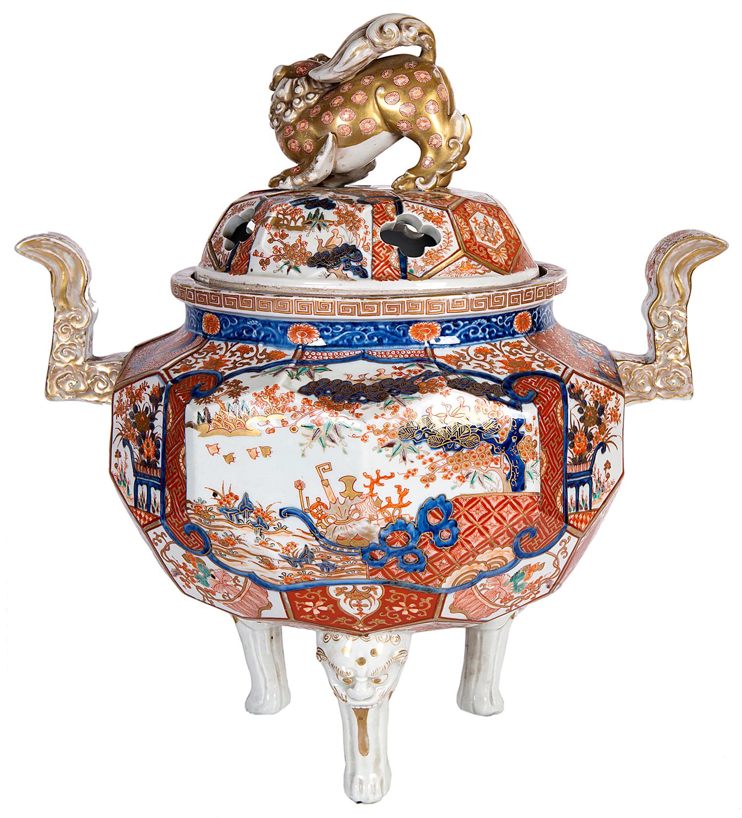 A very good quality 19th century Japanese Imari Koro, having a wonderful gilded dog of faux finial, stylized handles on either side, faceted panels with various scenes of birds, flowers and foliage, raised on three lion mask legs.