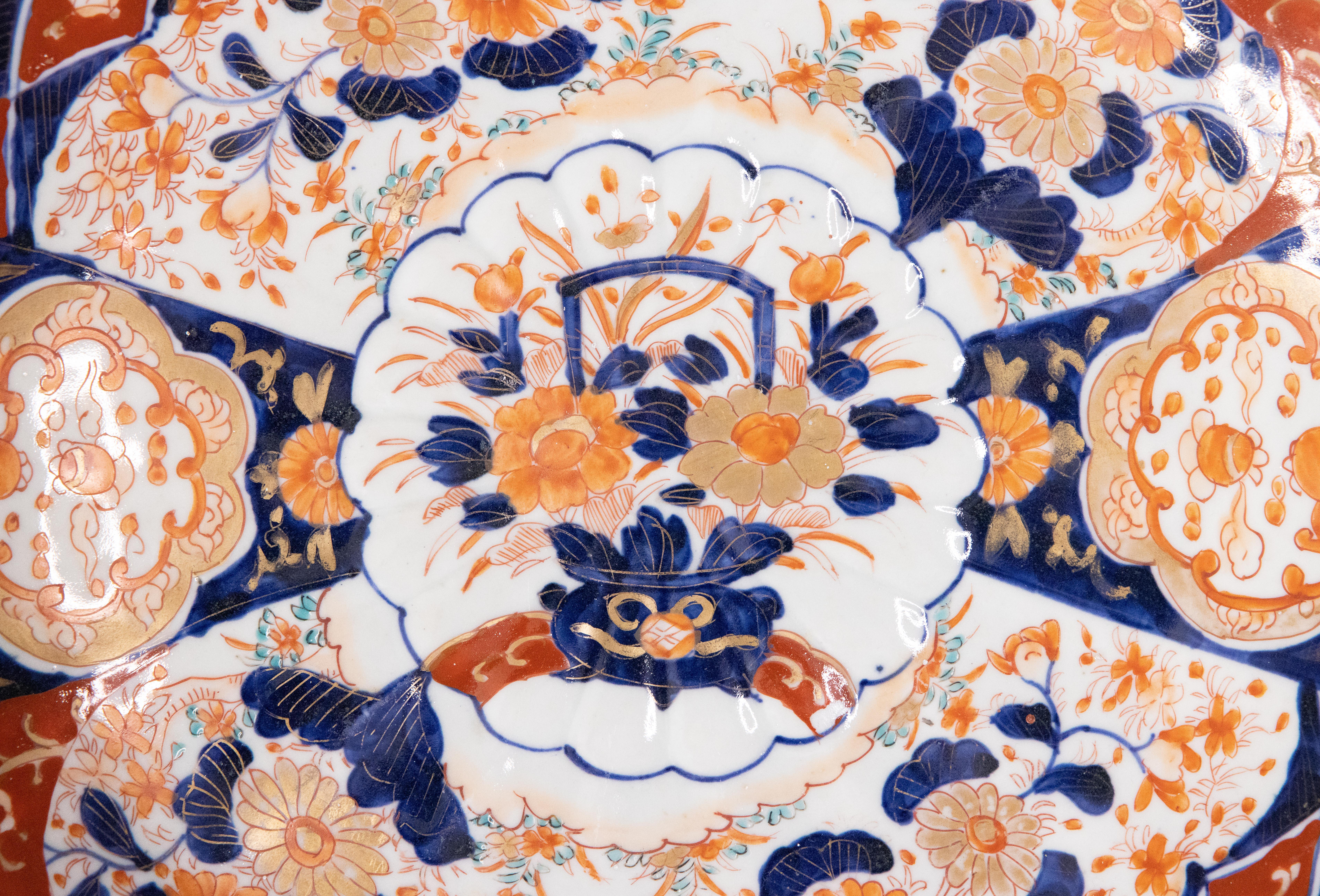 A gorgeous 19th-century Japanese Imari porcelain charger with a hand painted floral design in the traditional Imari colors with a beautiful pop of turquoise. This fine large plate has lovely scalloped edges and is quite heavy, weighing over 3 lbs.
