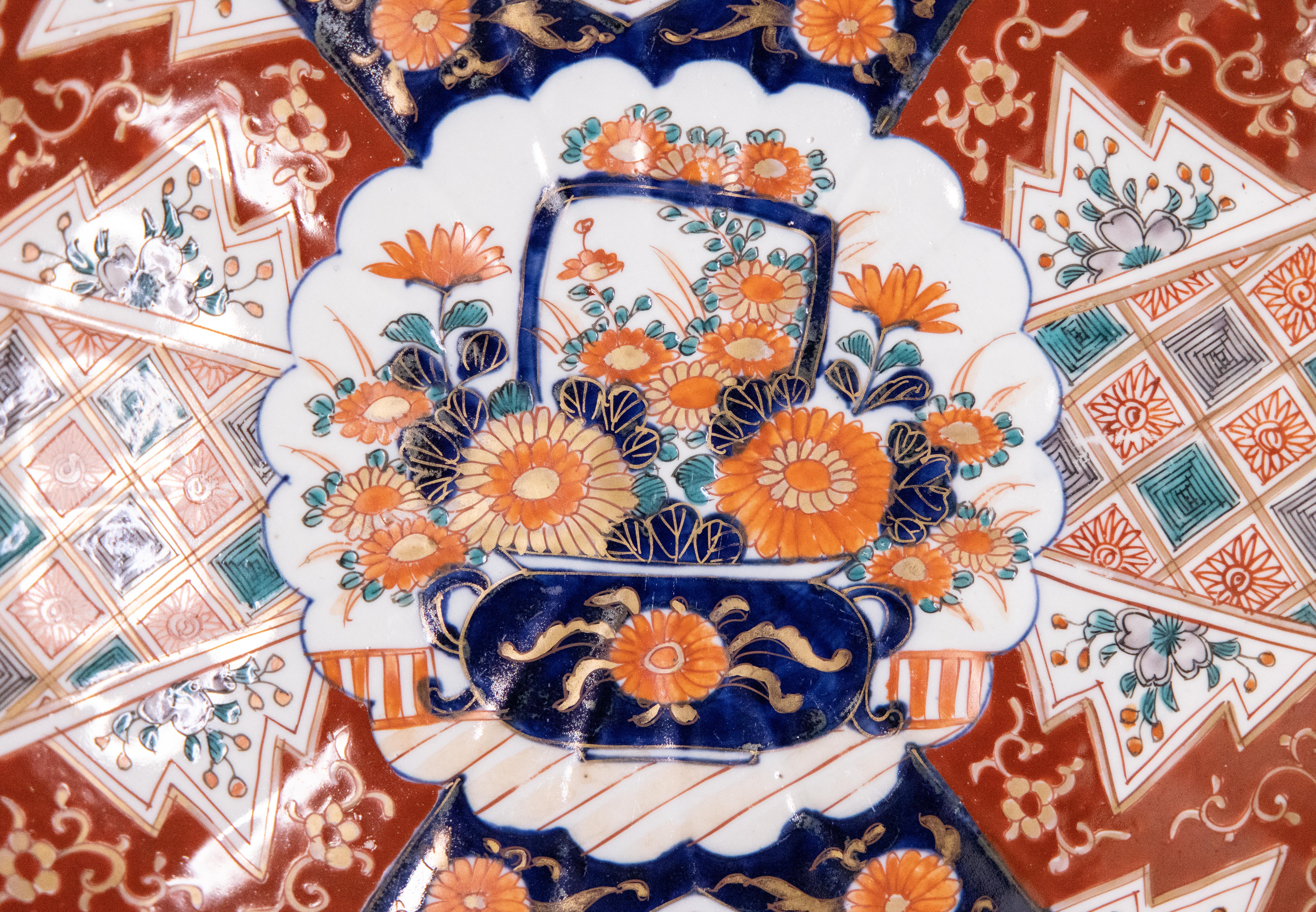 A gorgeous 19th-Century Japanese Imari porcelain charger with a hand painted floral design in the traditional Imari colors. This fine large plate has lovely scalloped edges and is quite heavy, weighing over 3 lbs. It would be wonderful added to a