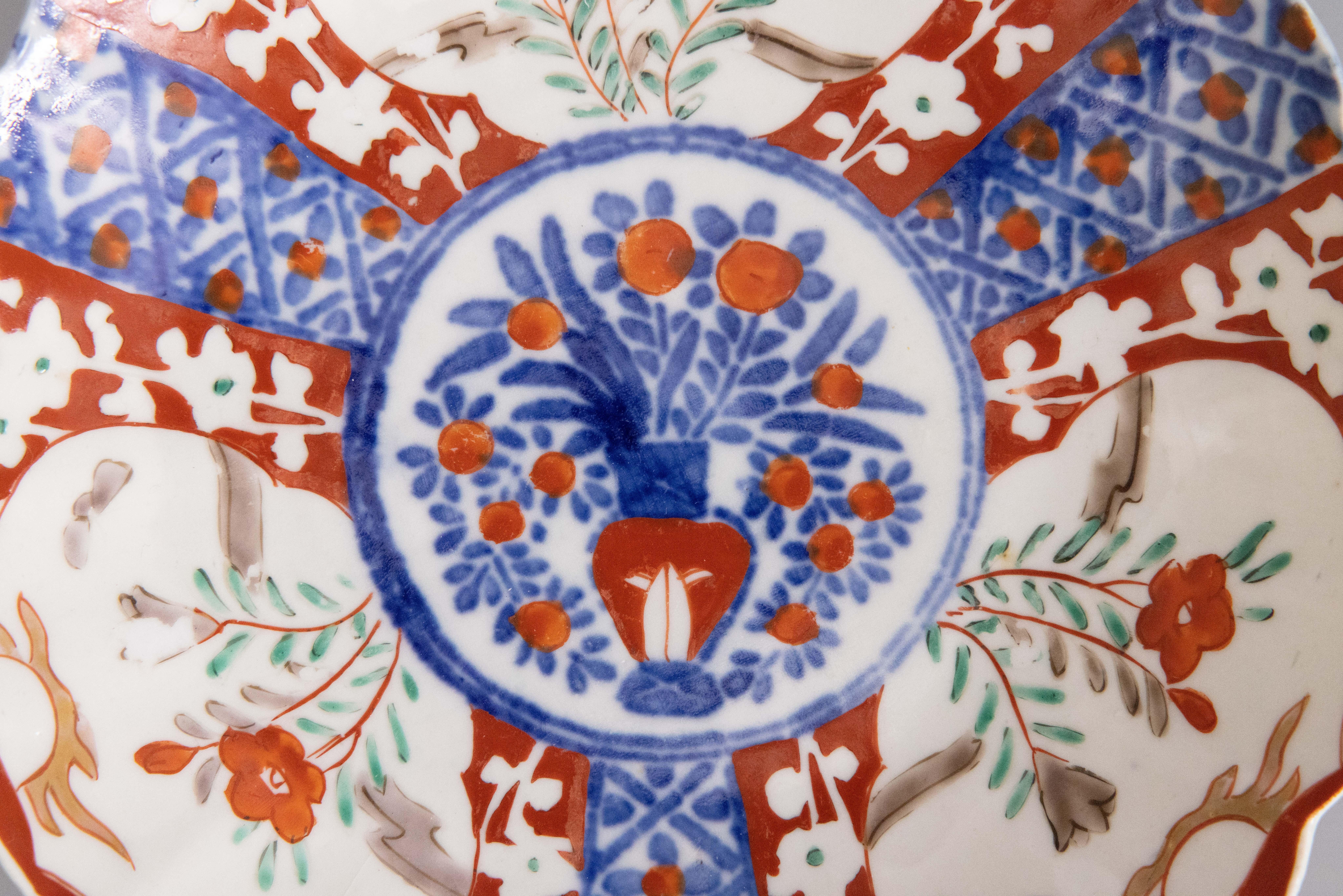 A gorgeous 19th-Century Japanese Imari porcelain plate with a hand painted floral design in the traditional Imari colors. This fine plate has lovely scalloped edges and displays beautifully.