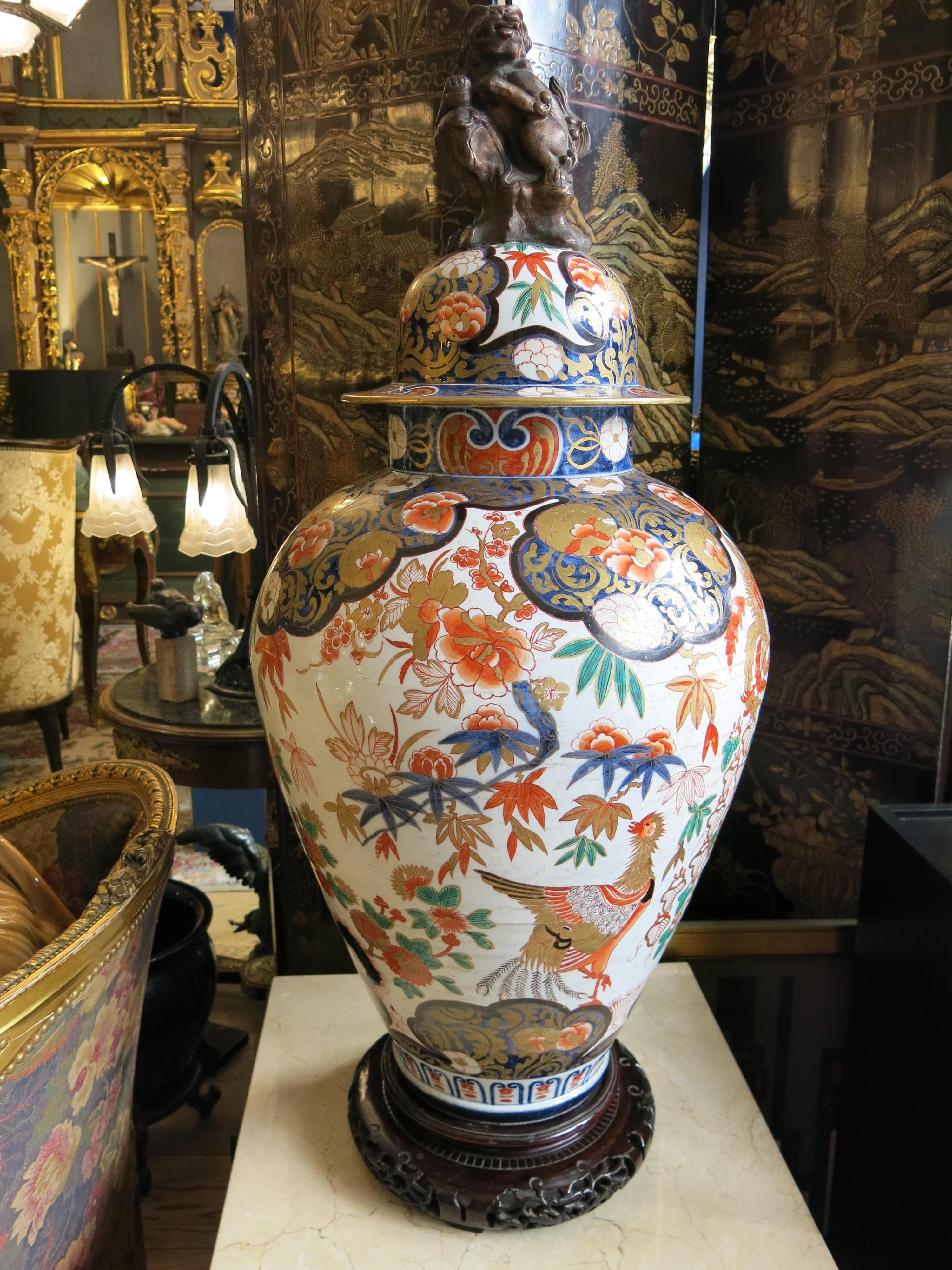 Voici un remarquable vase japonais Imari à couvercle du XIXe siècle, véritable témoignage de l'art et de l'artisanat de la période Edo. Cette pièce exquise est ornée d'un étonnant chien de fausse palme qui orne le couvercle, ajoutant une touche de