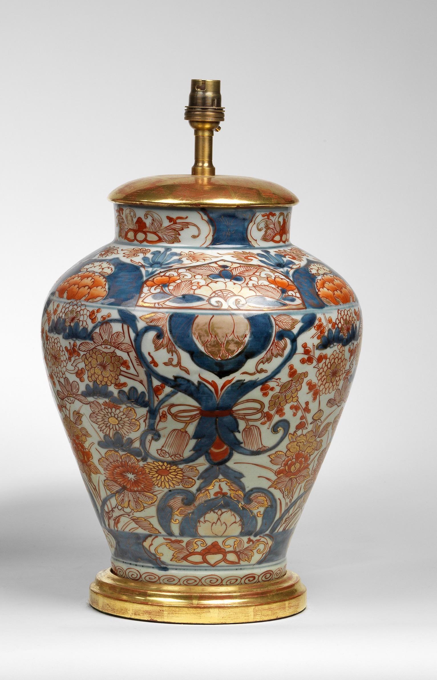 A fine 19th century Japanese Imari vase now mounted as a lamp, with typical tones of blue and coral on a white ground, profusely decorated and finely painted with chrysanthemums, foliage and phoenix birds. Fitted with a hand-gilded turned base and