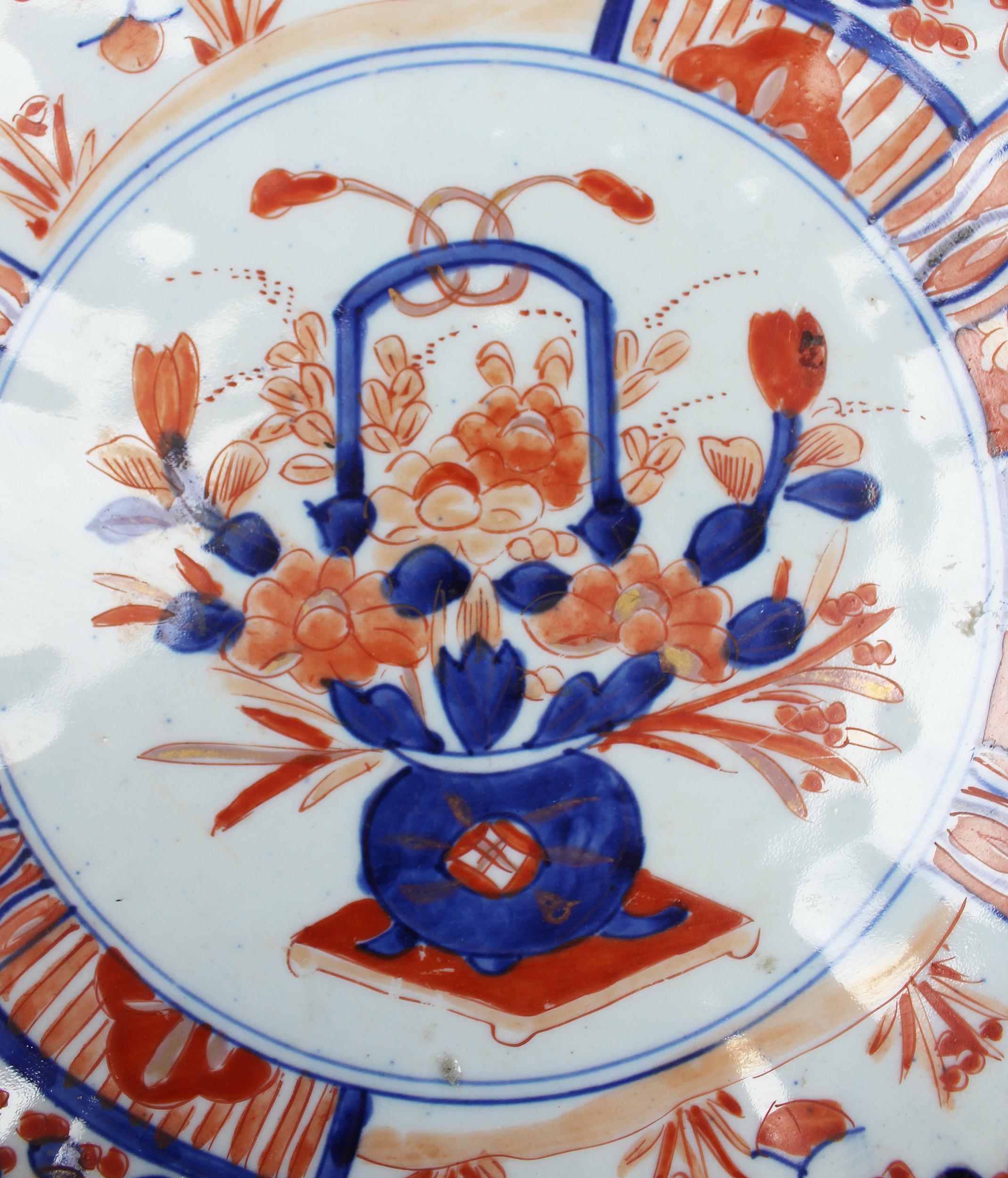 19th century Japanese Imari ware porcelain hand painted plate with flower motifs in red and blue, typical of this style. 

 