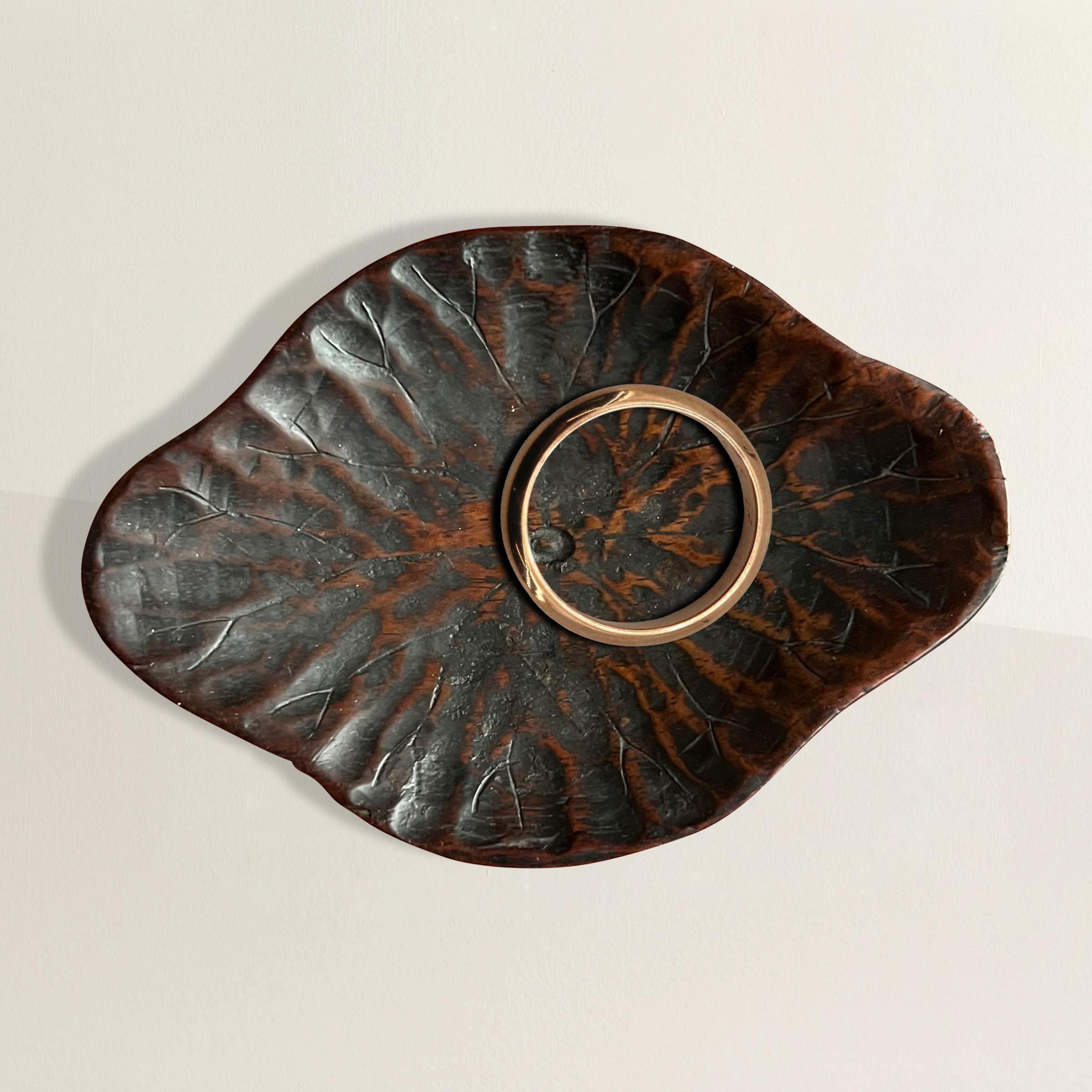 Questo squisito piatto in legno intagliato del periodo Meiji giapponese (1868-1912) raffigura magistralmente una foglia di loto con dettagli intricati. La superficie superiore del piatto mostra le delicate venature della foglia di loto, ogni linea