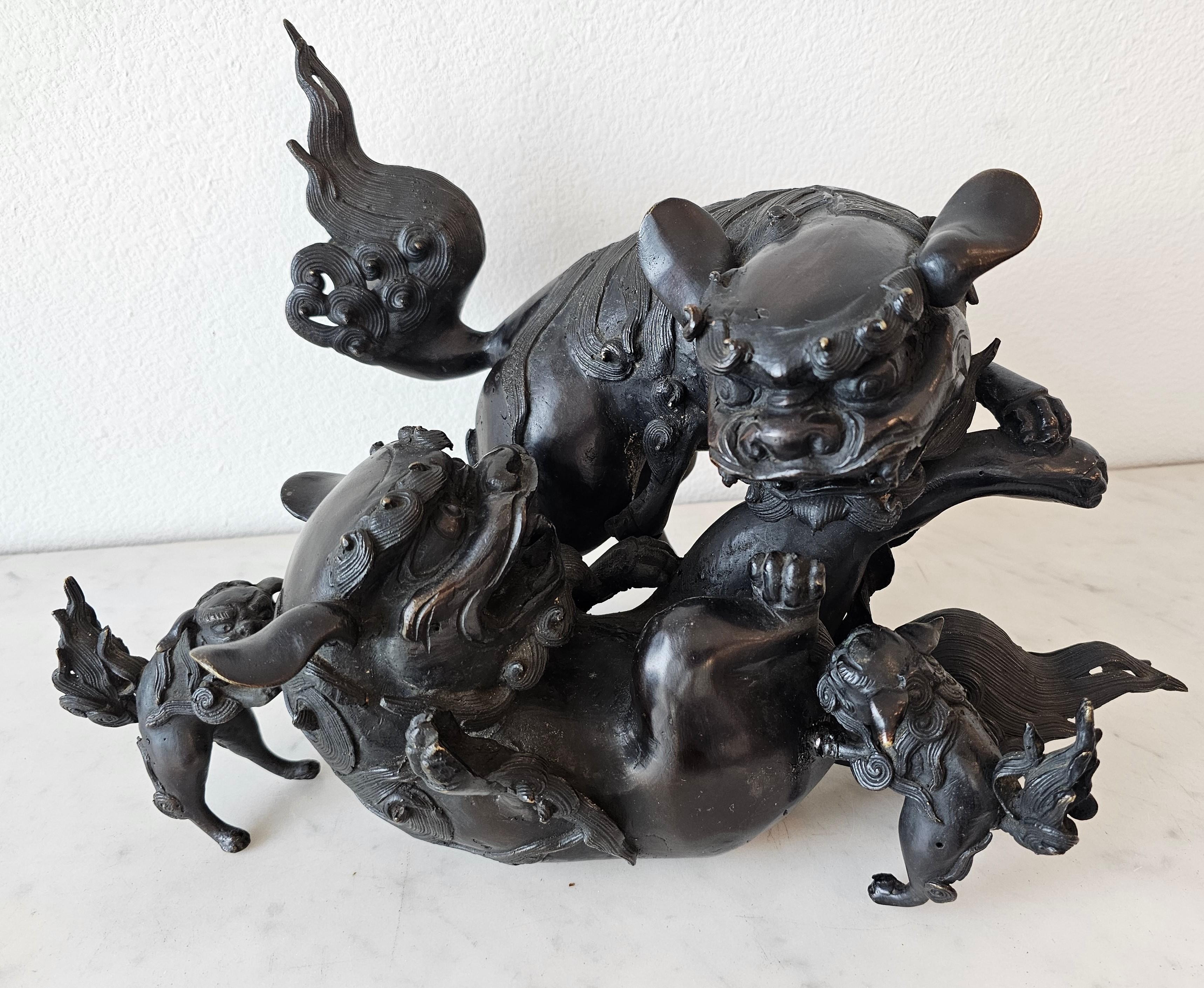 A large and impressive Japanese Meiji period (1852-1912) patinated bronze guardian lion censer.

Late 19th century, Japan, exceptionally executed, the group consisting of four shishi foo dogs, depicting two large foos at play frolicking and mock