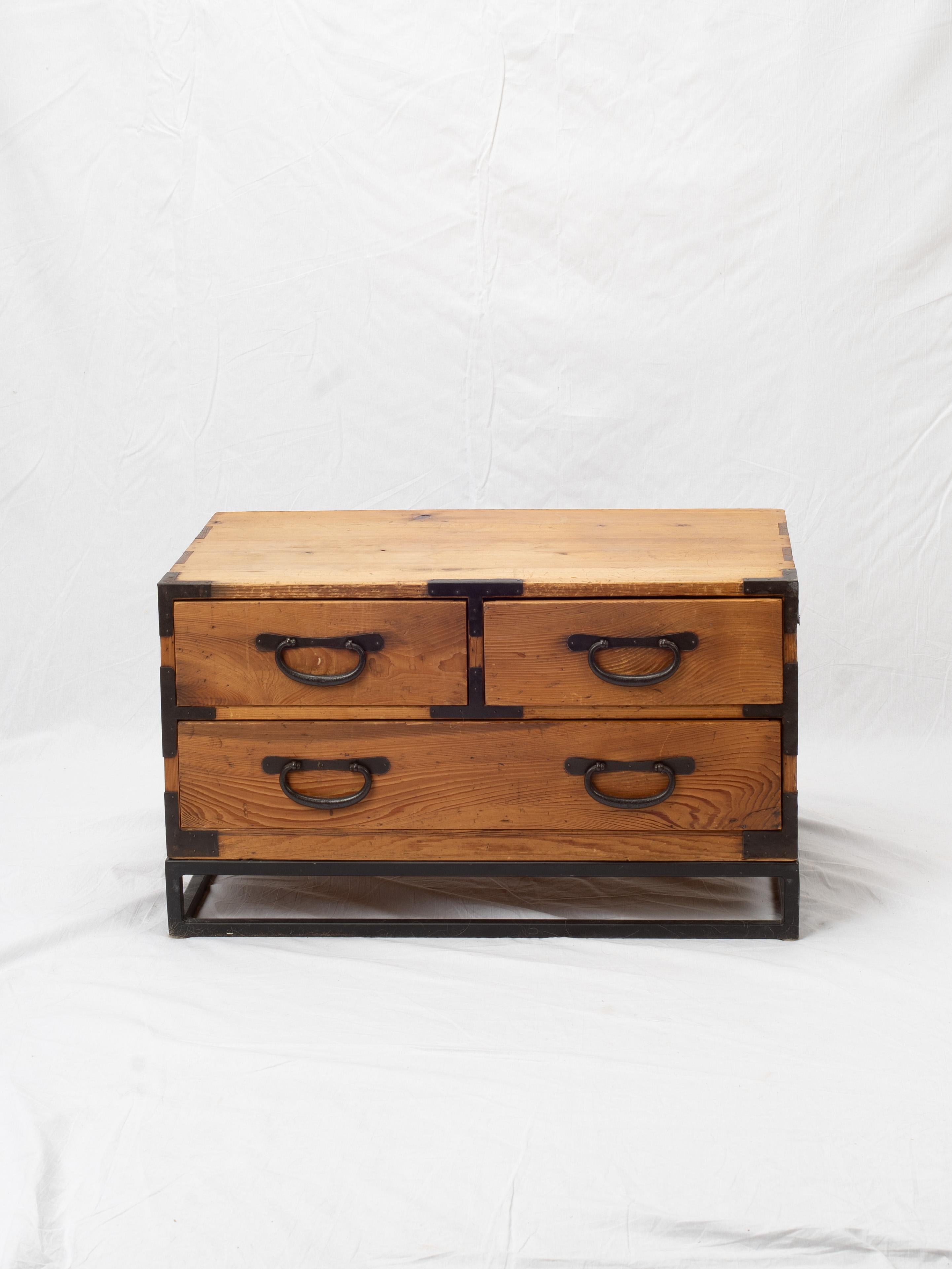 Construido con sugi (cedro japonés), este baúl para kimono de vestir está decorado con soportes y herrajes de hierro ennegrecido, y descansa sobre un soporte de hierro. La mesa auxiliar tiene 3 cajones con una silueta minimalista.

Mide 31