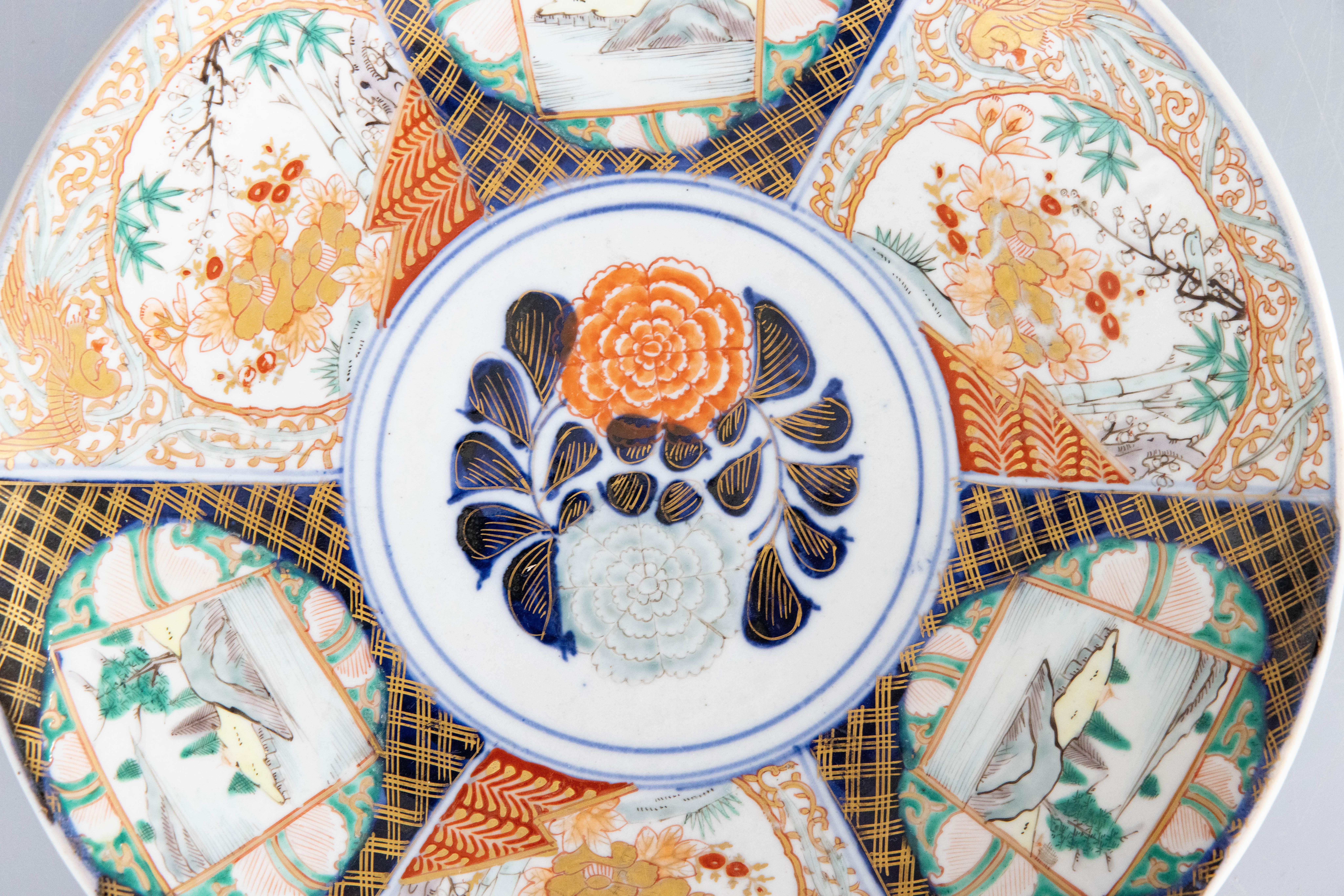 A gorgeous 19th-Century Japanese Meiji Period Imari porcelain charger with a hand painted floral design in the traditional Imari colors with stunning gilt accents. This fine large plate has lovely hand painted details and is quite heavy, weighing